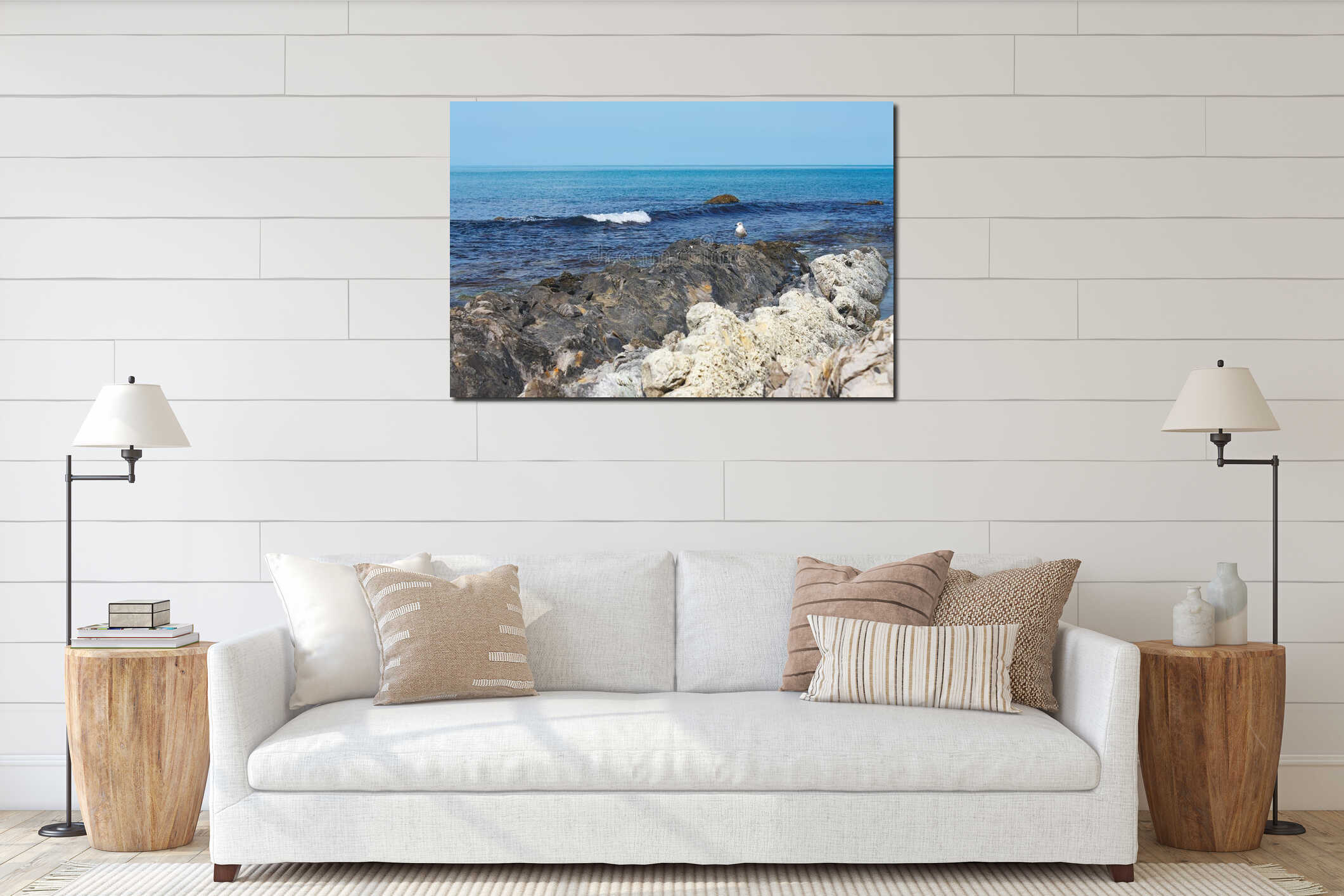 Lonely seagull on a beautiful rocky sea shore against calm sea interior mockup