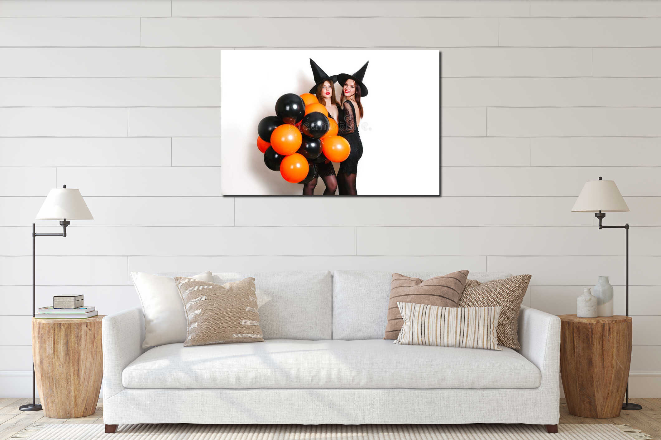 Two happy women in black witch halloween costumes with orange and black balloon on party over white background interior mockup