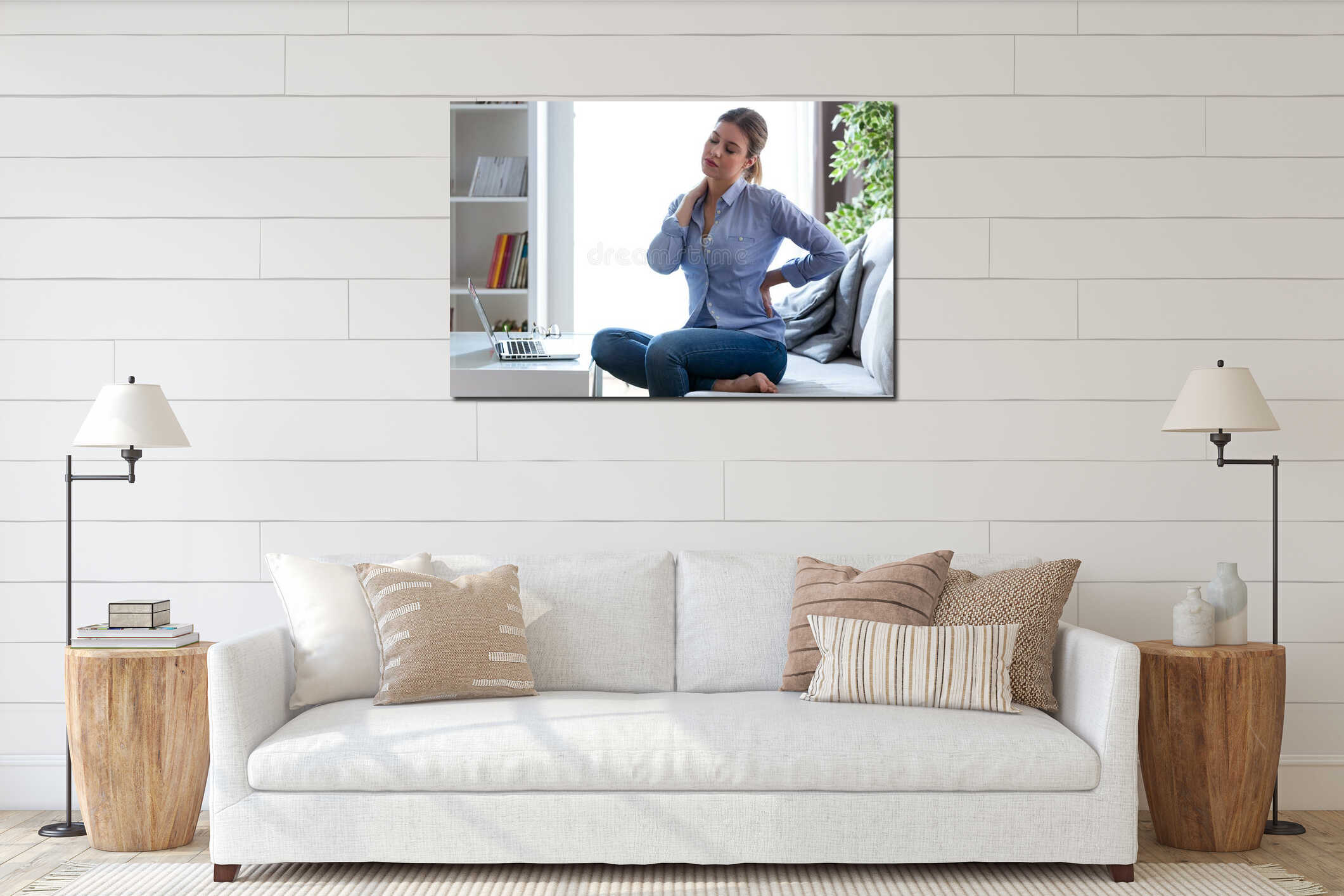 Tired young woman with shoulder and back pain sitting on the couch at home. interior mockup