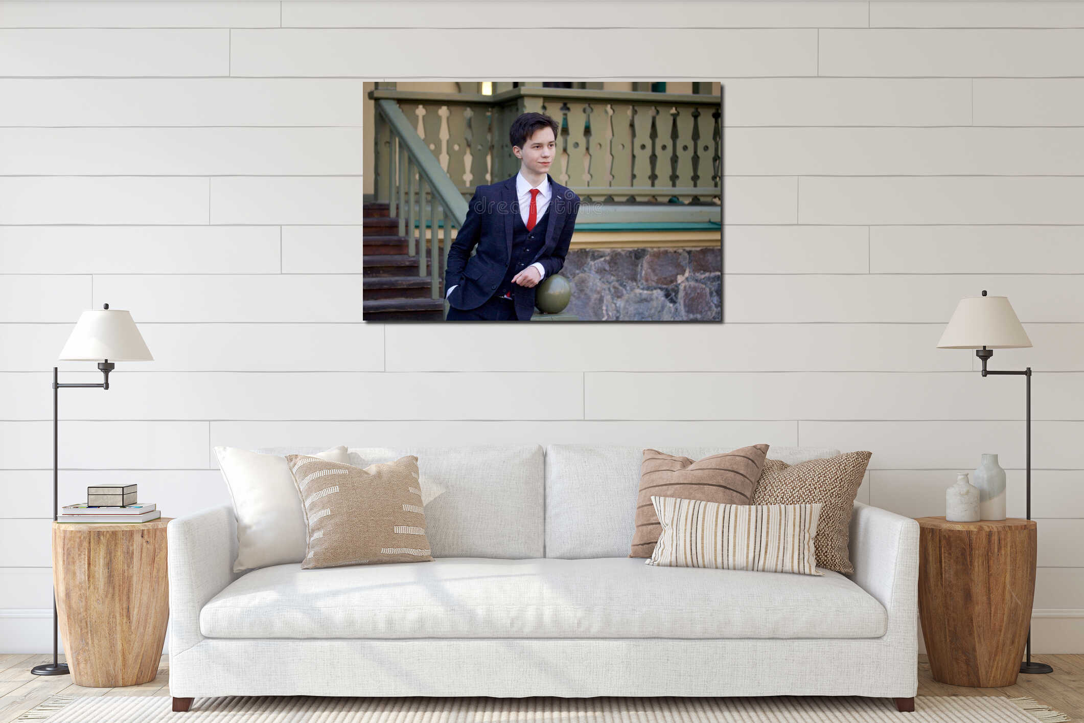 A young man, a teenager, in a classic suit. It stands, leaning on the railing of a wooden staircase. interior mockup