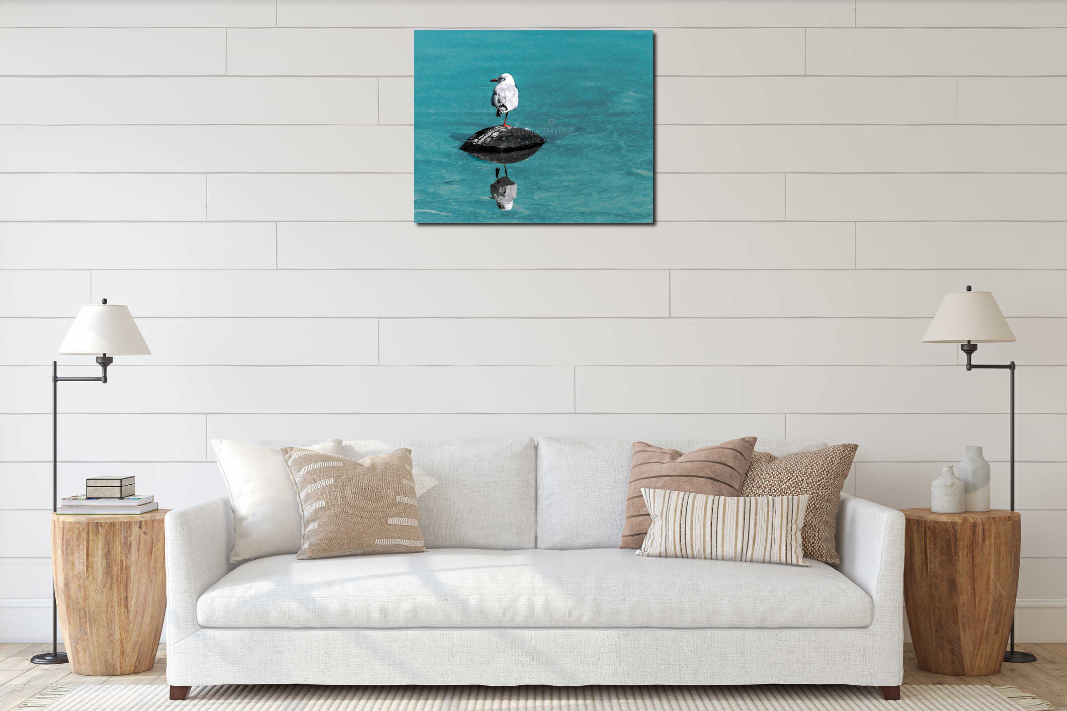 Single small white seagull bird sitting on old black rubber car tire in sea with specular reflection in water. Copy interior mockup