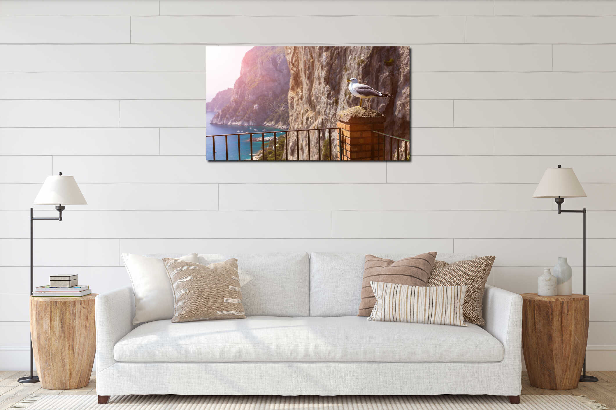 A seagull bird sits on a balcony against the background of the sea and rocks - a travel or natural background. interior mockup