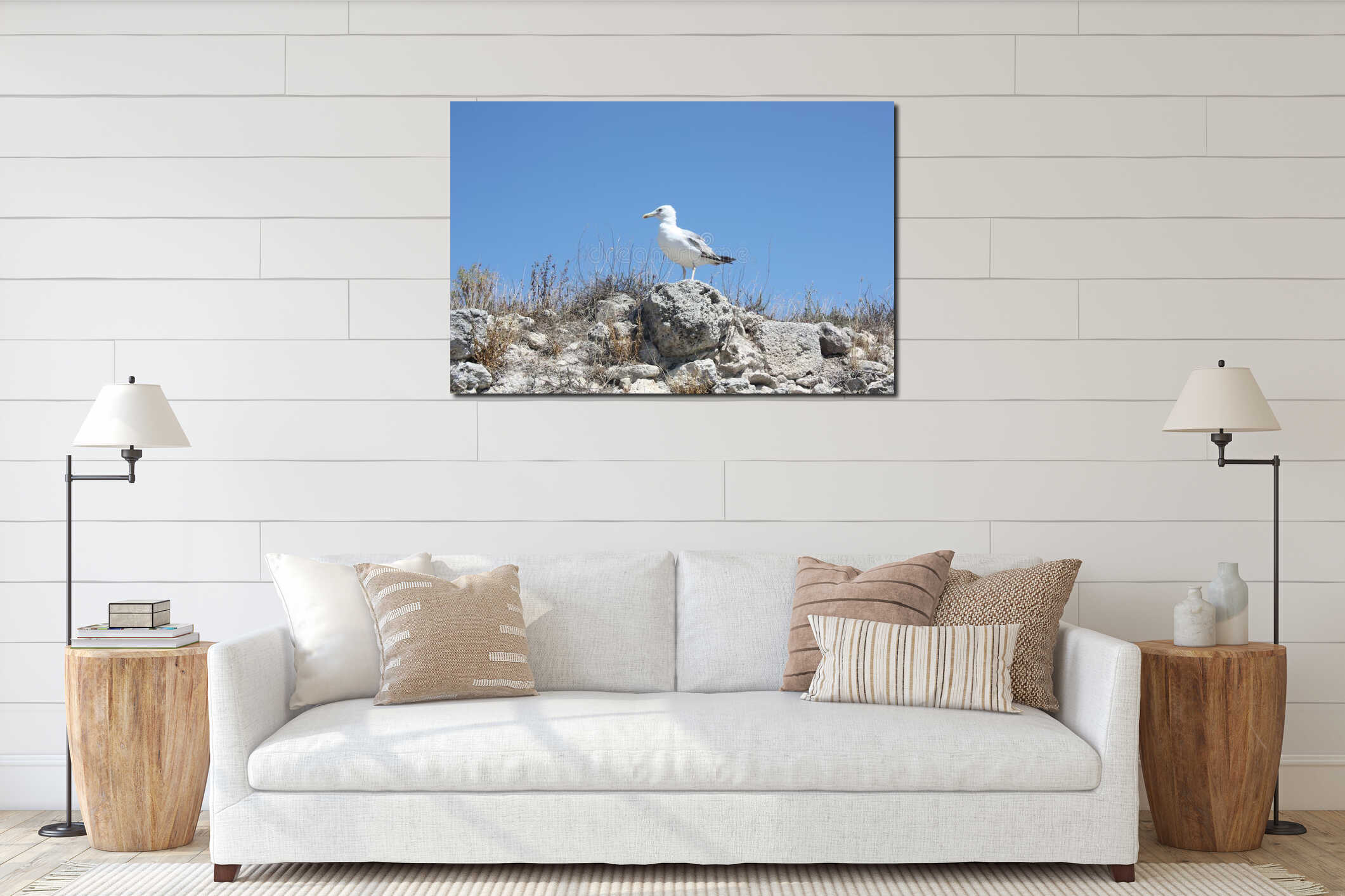 A seagull sits on rocks against the blue sky. interior mockup