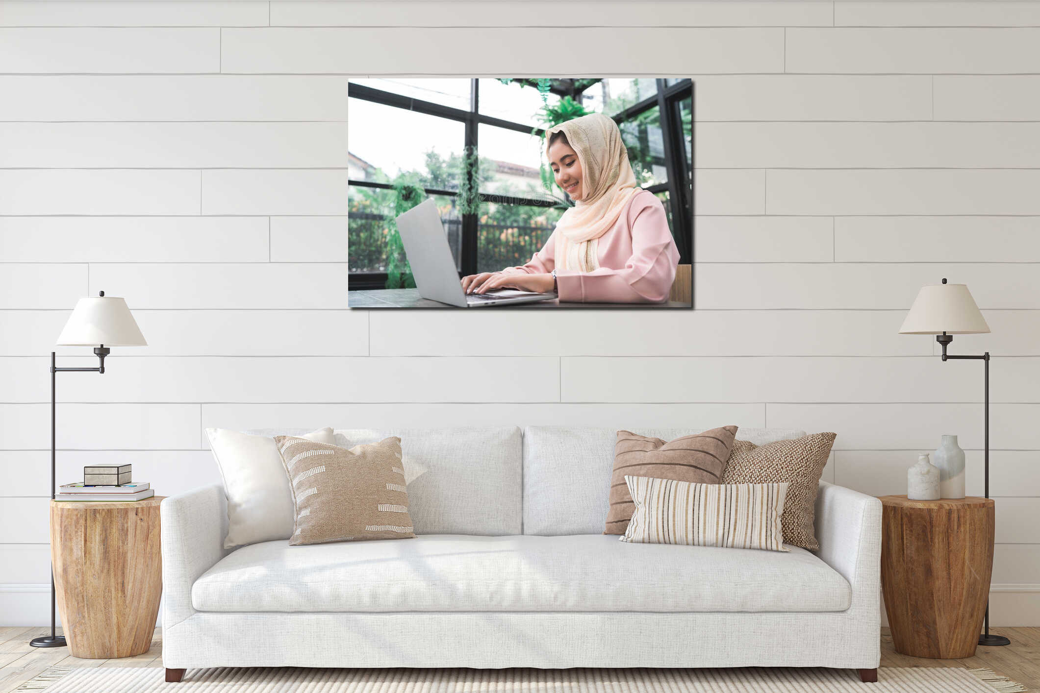 Beautiful young smiling asian muslim woman working on laptop sitting in living room at home. interior mockup