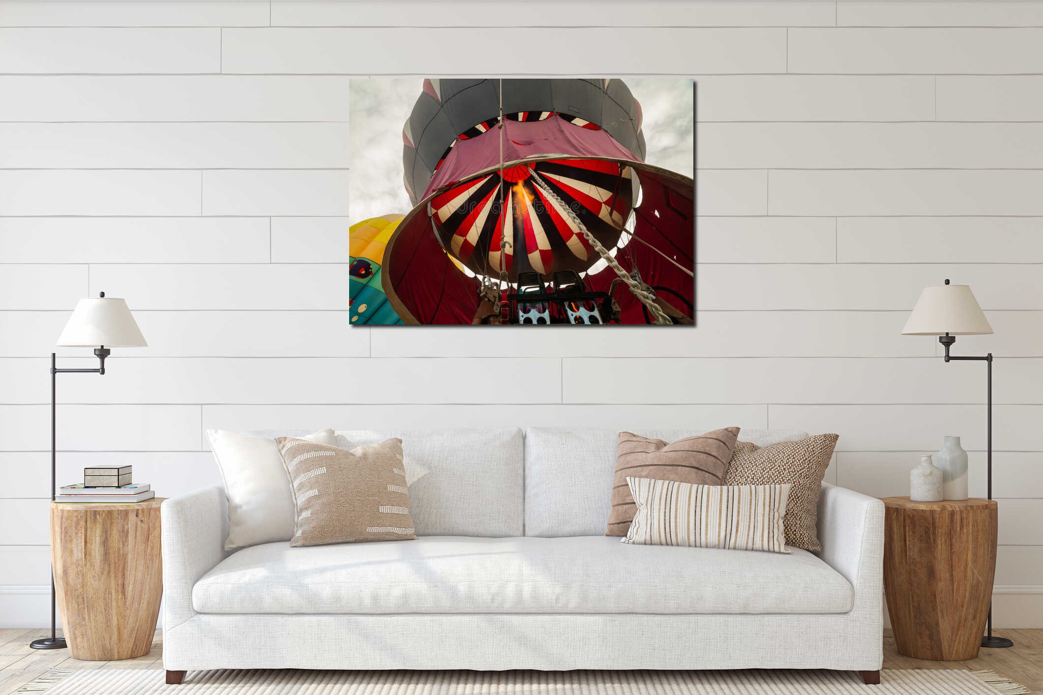 A horizontal wide angle view of a red white and black striped hot air balloon being filled from the viewpoint of the basket interior mockup
