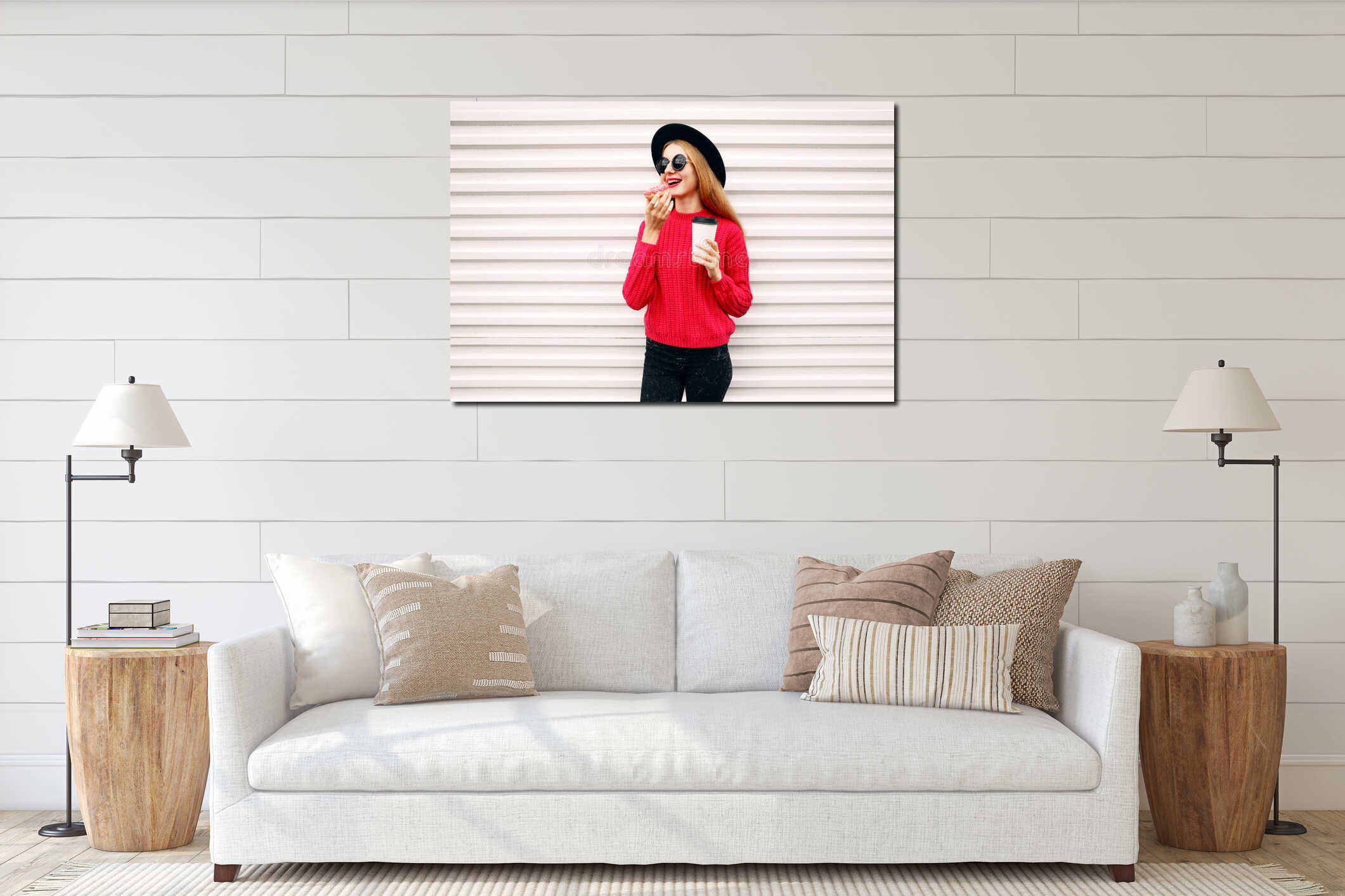 Portrait cheerful young woman eating sweet donut and holding coffee cup on city street white wall interior mockup