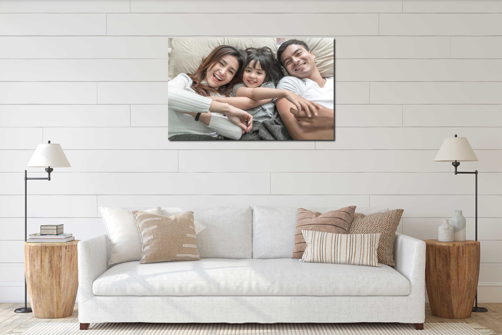 Elevated view portrait of happy family lying on bed and looking up and holding hands. interior mockup