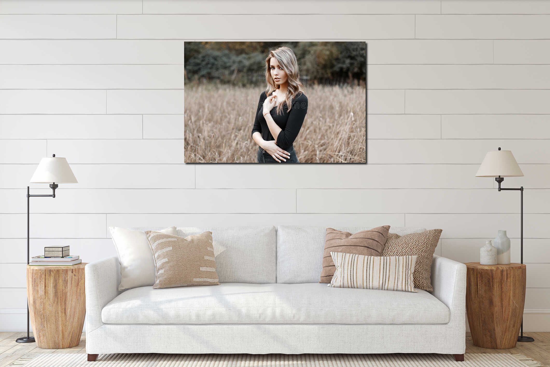 Beautiful pretty sexy young woman in a black stylish T-shirt with blond hair in trendy jeans poses in a field on a warm autumn day interior mockup