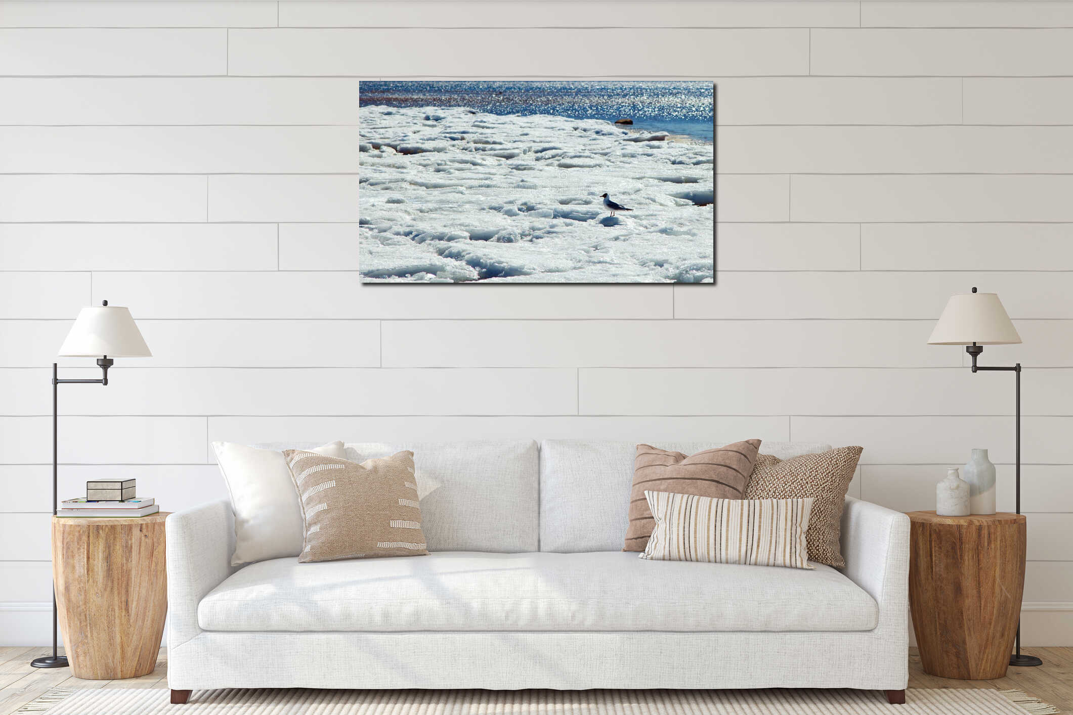 A seagull standing in the spring snow against the background of the water of the sea bay in spring in sunny weather interior mockup