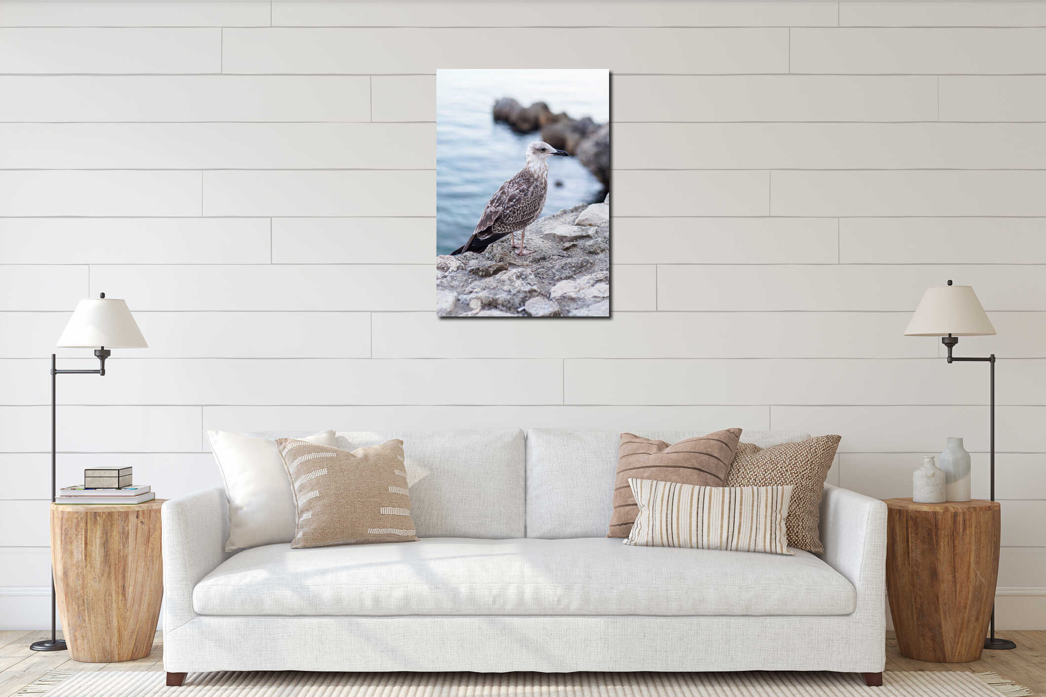 A gray seagull sits on a stone against the sea interior mockup