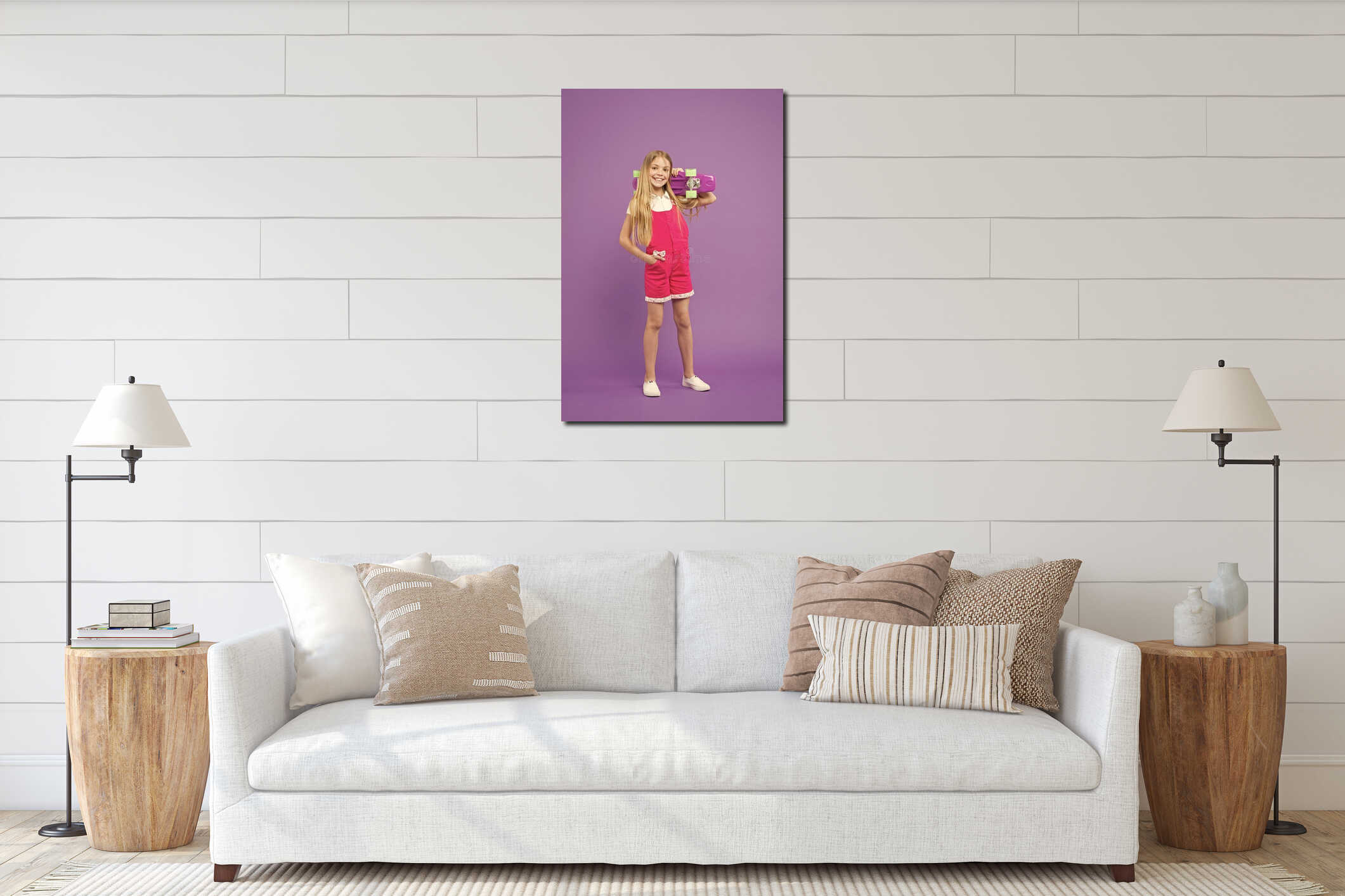 Child with charming smile isolated on violet background. Girl with blond hair in pink jumpsuit and white sneakers. Kid interior mockup