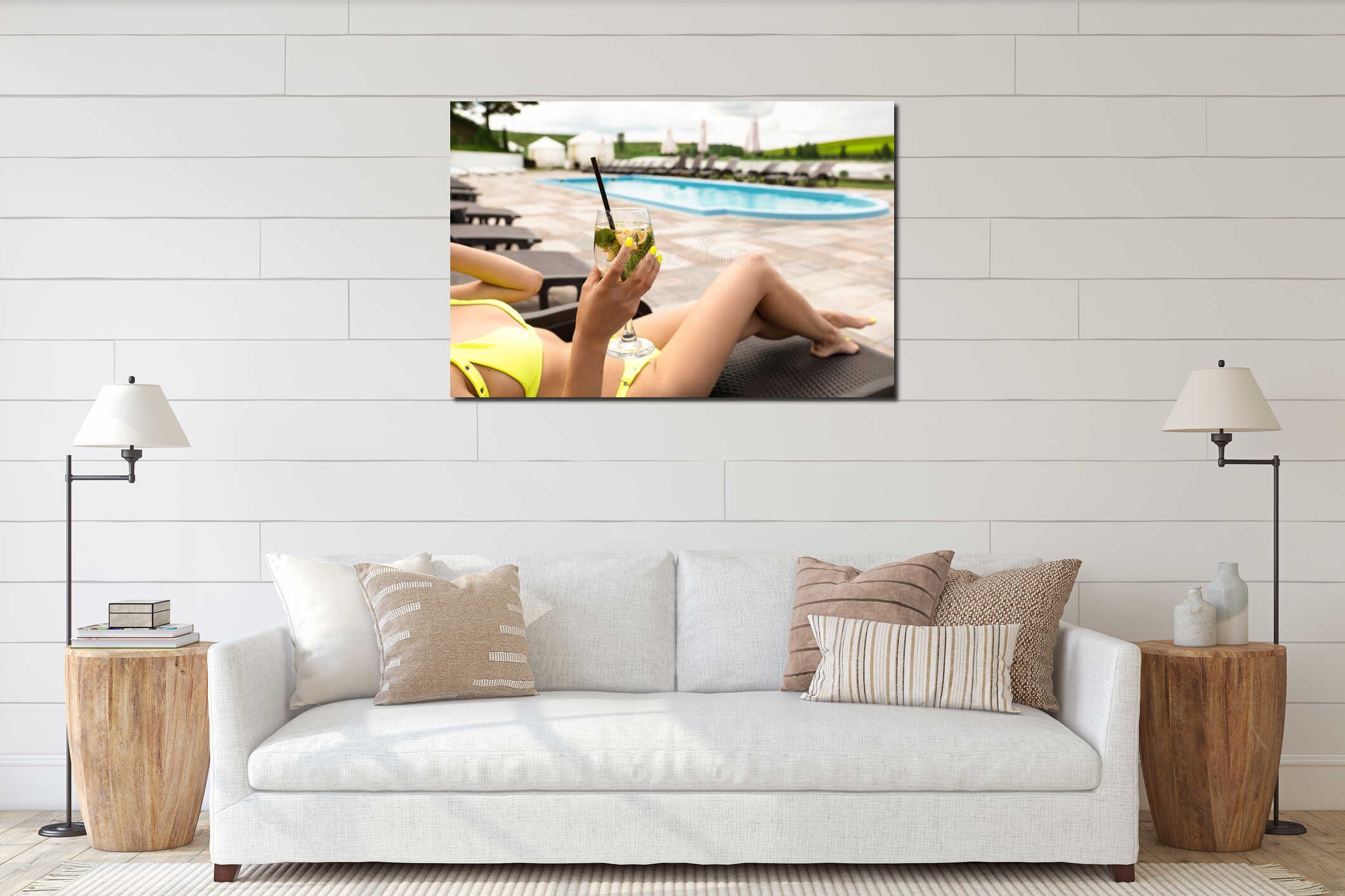 Young beautiful woman in sexy yellow swimsuit lying on lounger suntanning at hotel swimmingpool drinking cocktail on interior mockup
