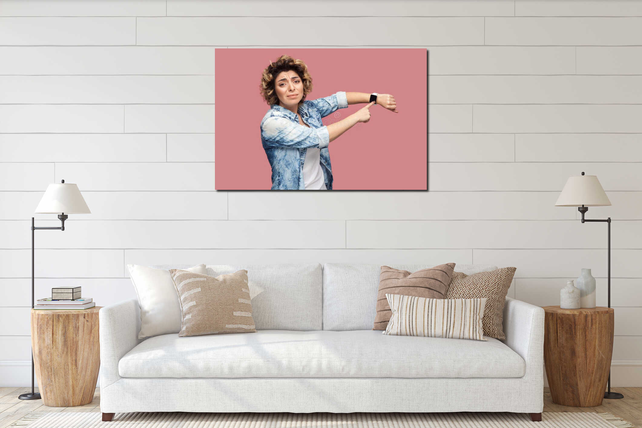 I need more time. Portrait of young pleased woman with curly hairstyle in casual blue shirt standing and pointing at her smart interior mockup
