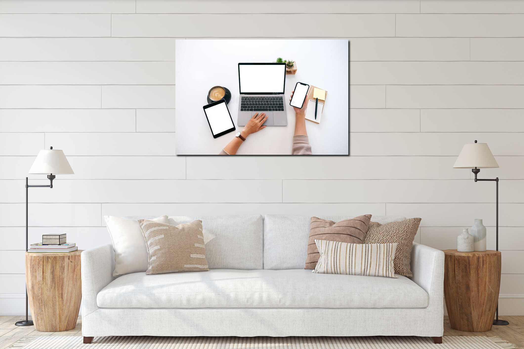 Hands holding a blank white screen mobile phone with laptop computer and tablet pc on the table in office interior mockup