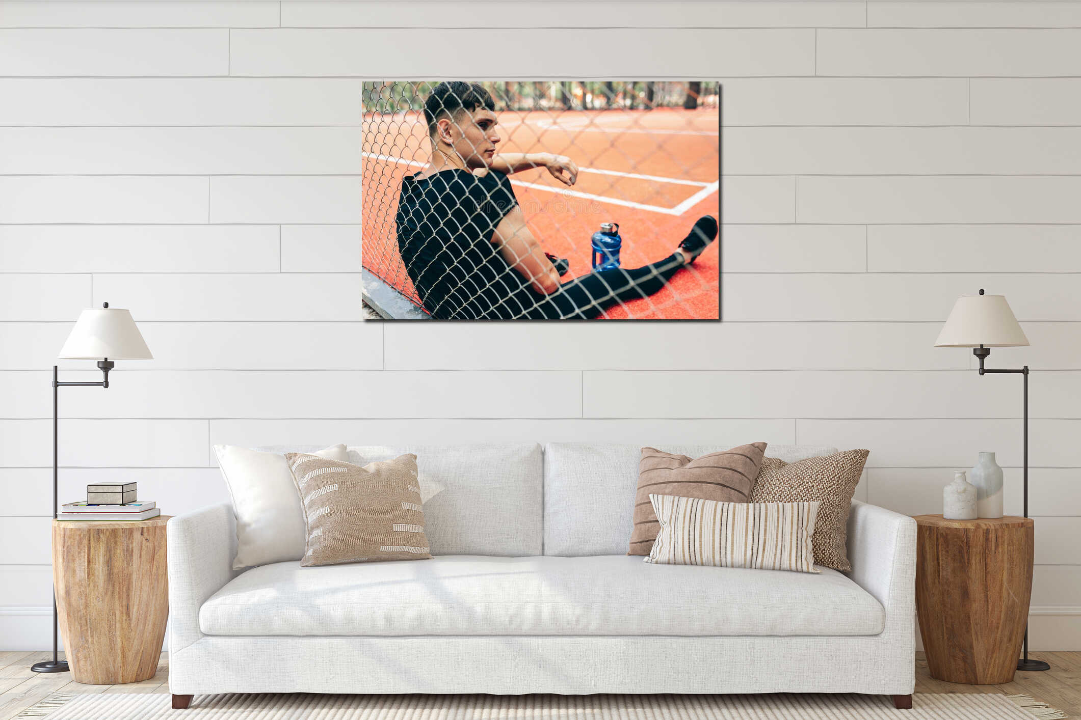 Rear view of handsome young fitness man resting after workout, with a blue bottle of water, sitting on sportsground. Healthy male interior mockup
