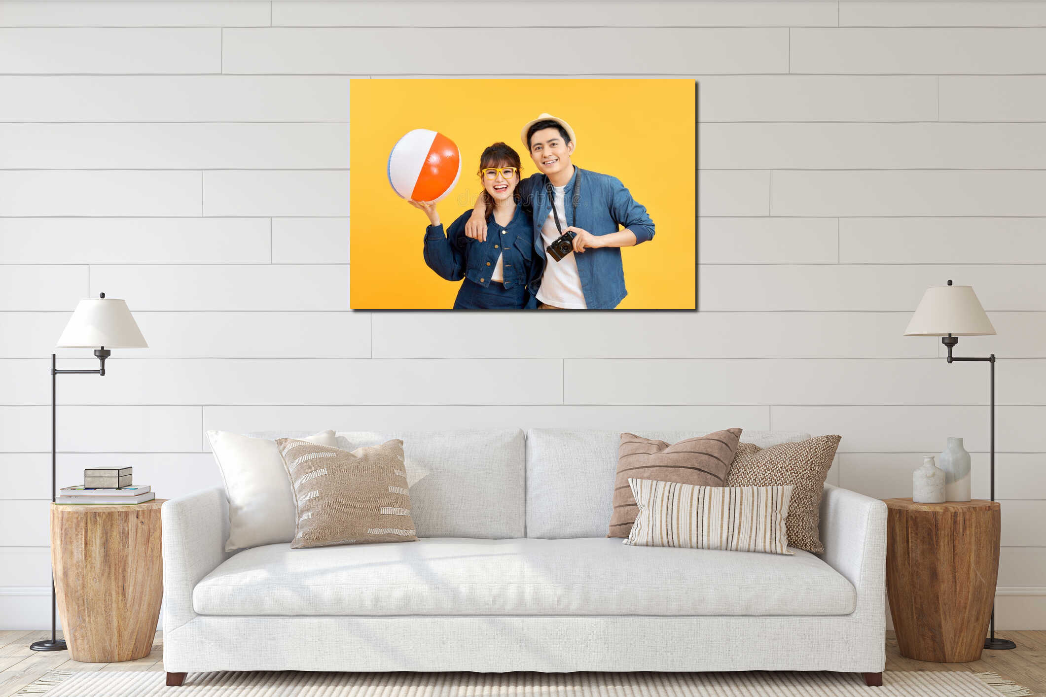 Young smiling happy couple tourists in casual summer attire with beach accessories on colorful yellow studio background interior mockup