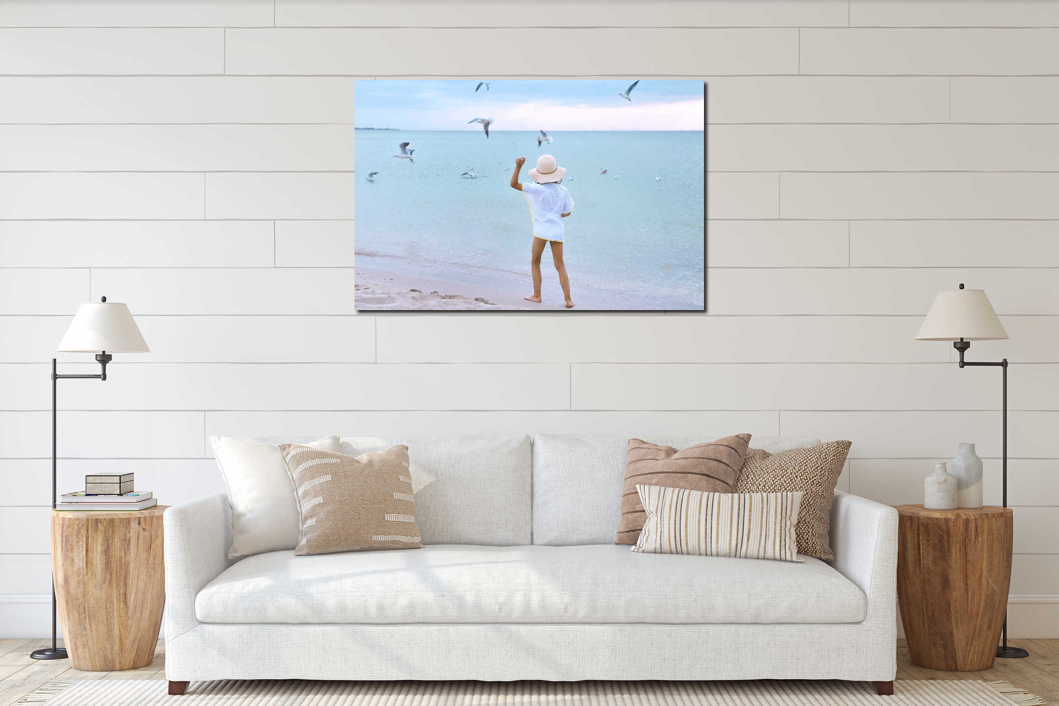 Little cute girl in hat feeds seagulls on the beach. interior mockup