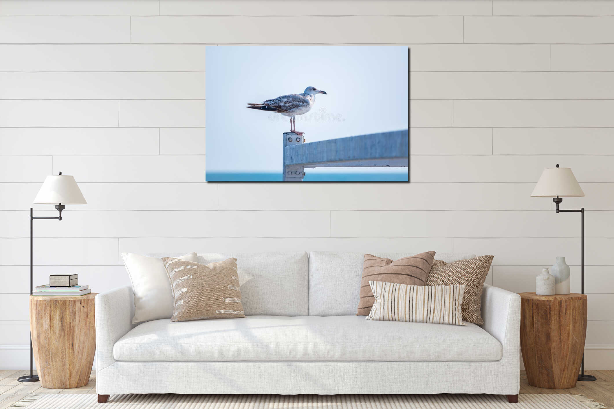 A seagull sits on a fence against the sky interior mockup