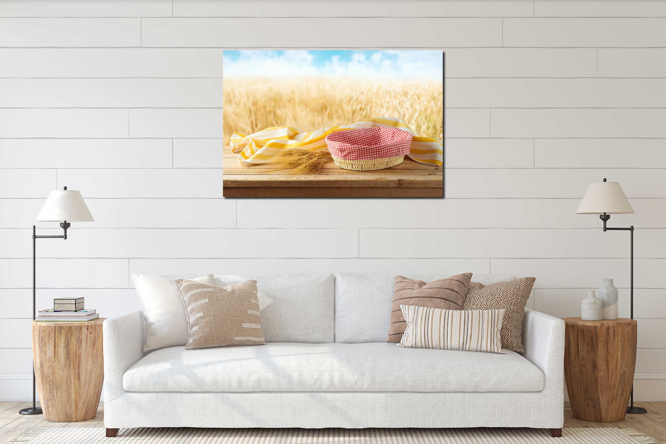 Empty basket with wheat and tablecloth on wooden table over blurred wheat field background. Harvest mock up for design interior mockup