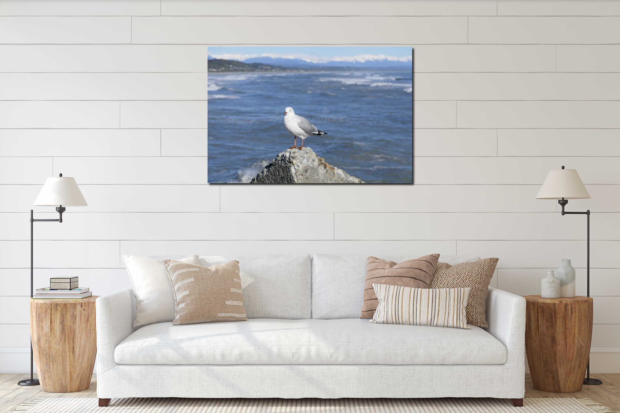 Seagull standing on a rock with the sea and snow covered mountains in the background interior mockup