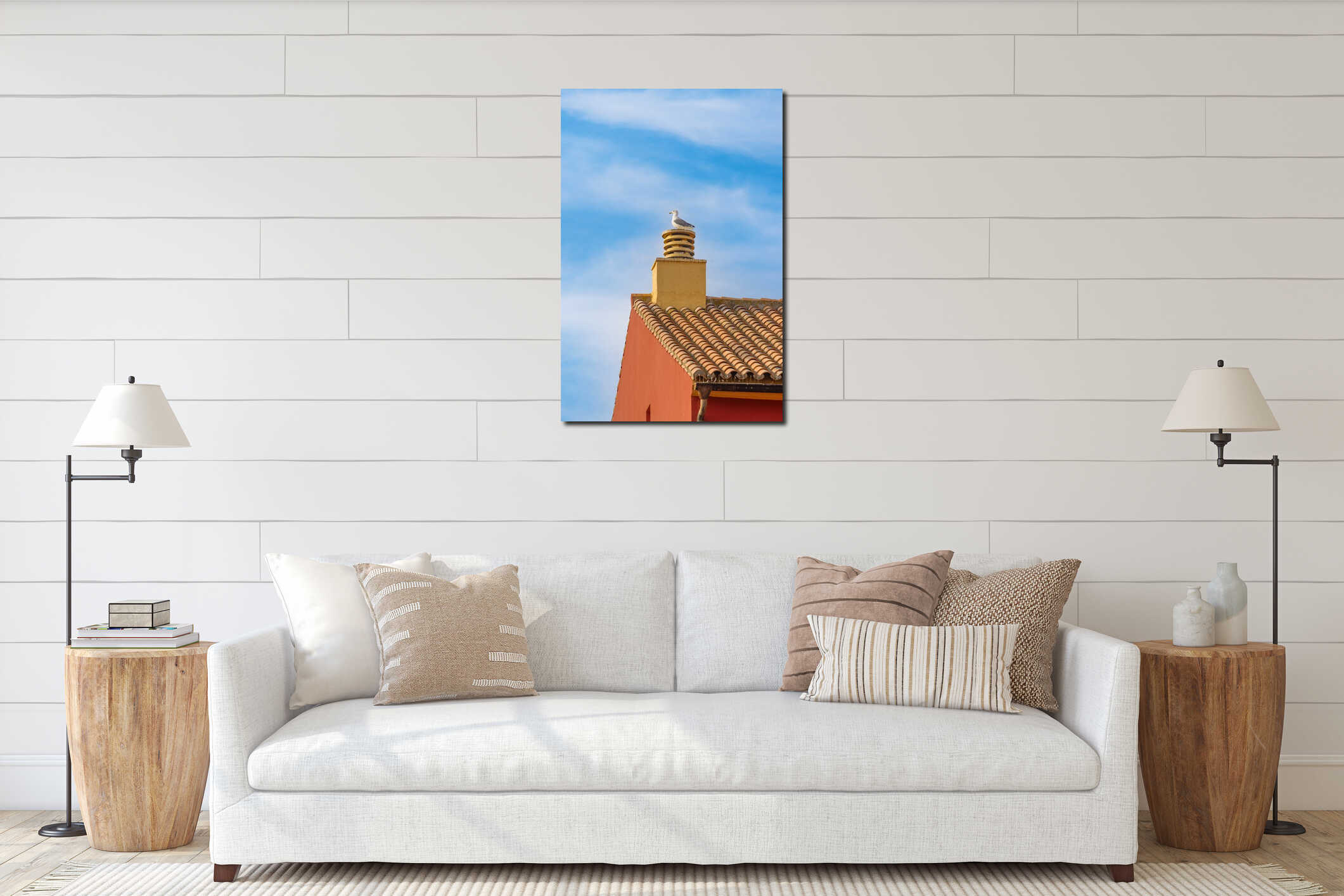 Seagull sits on a chimney on a roof against a blue sky with white clouds interior mockup