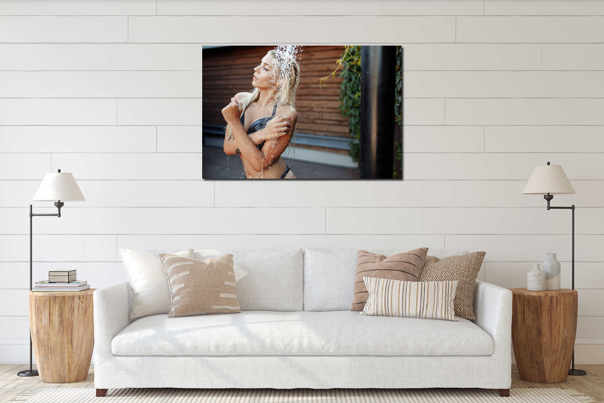 Shooting in the aquazone with falling water drops. A girl with blond hair in a black swimsuit under a cold shower in a interior mockup
