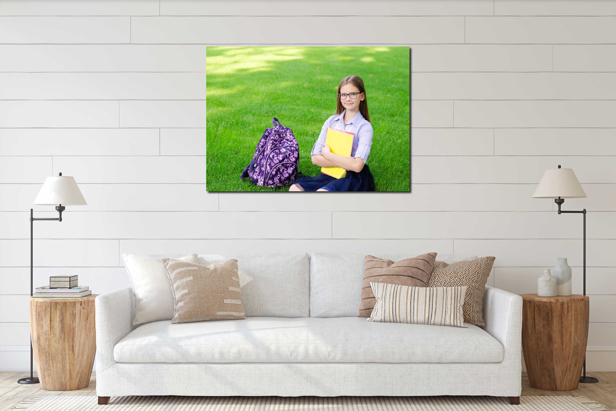 Back to school. Education concept. Cute smiling schoolgirl in glasses sitting on grass interior mockup