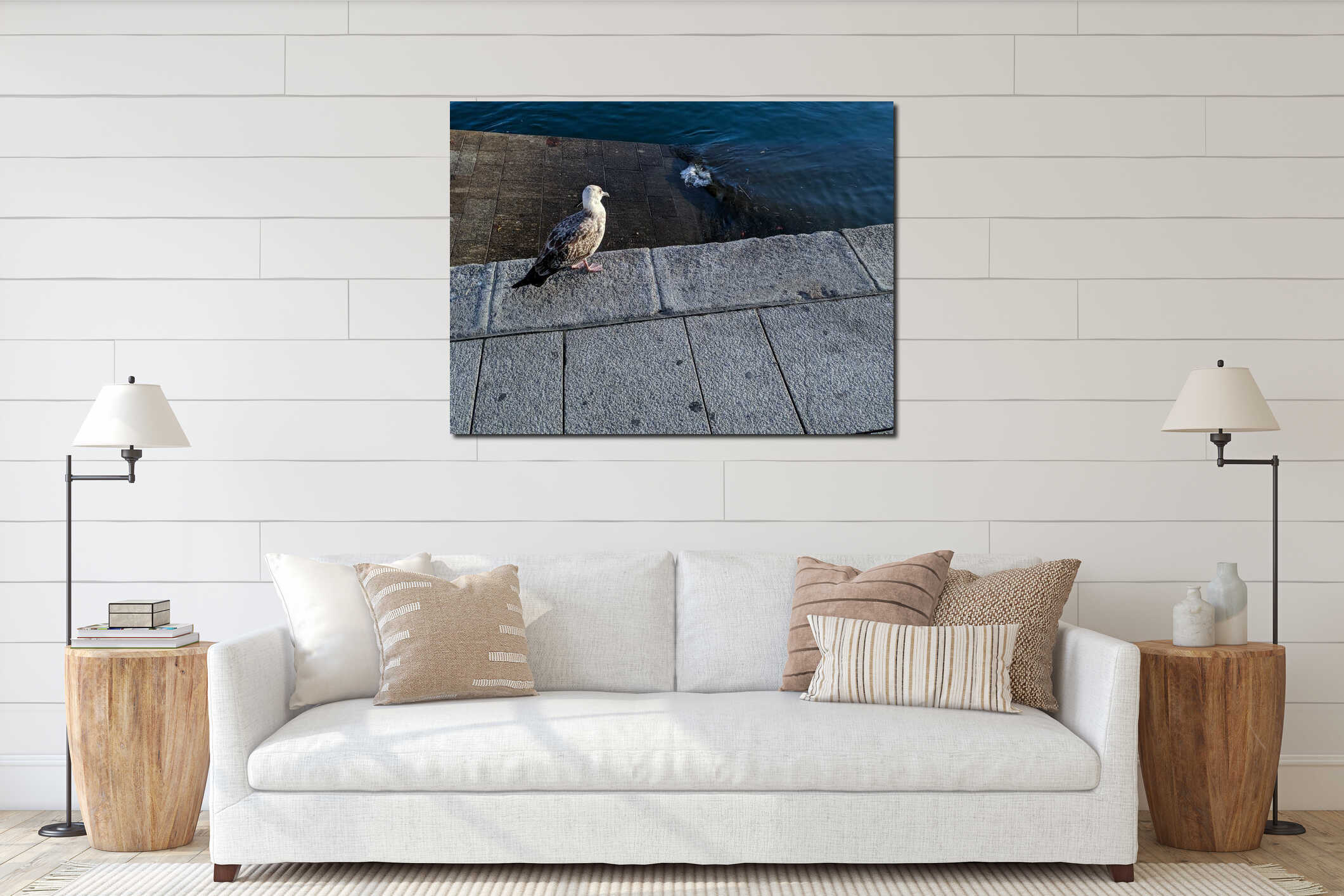 High angle shot of a seagull by the sea perched on a concrete surface interior mockup