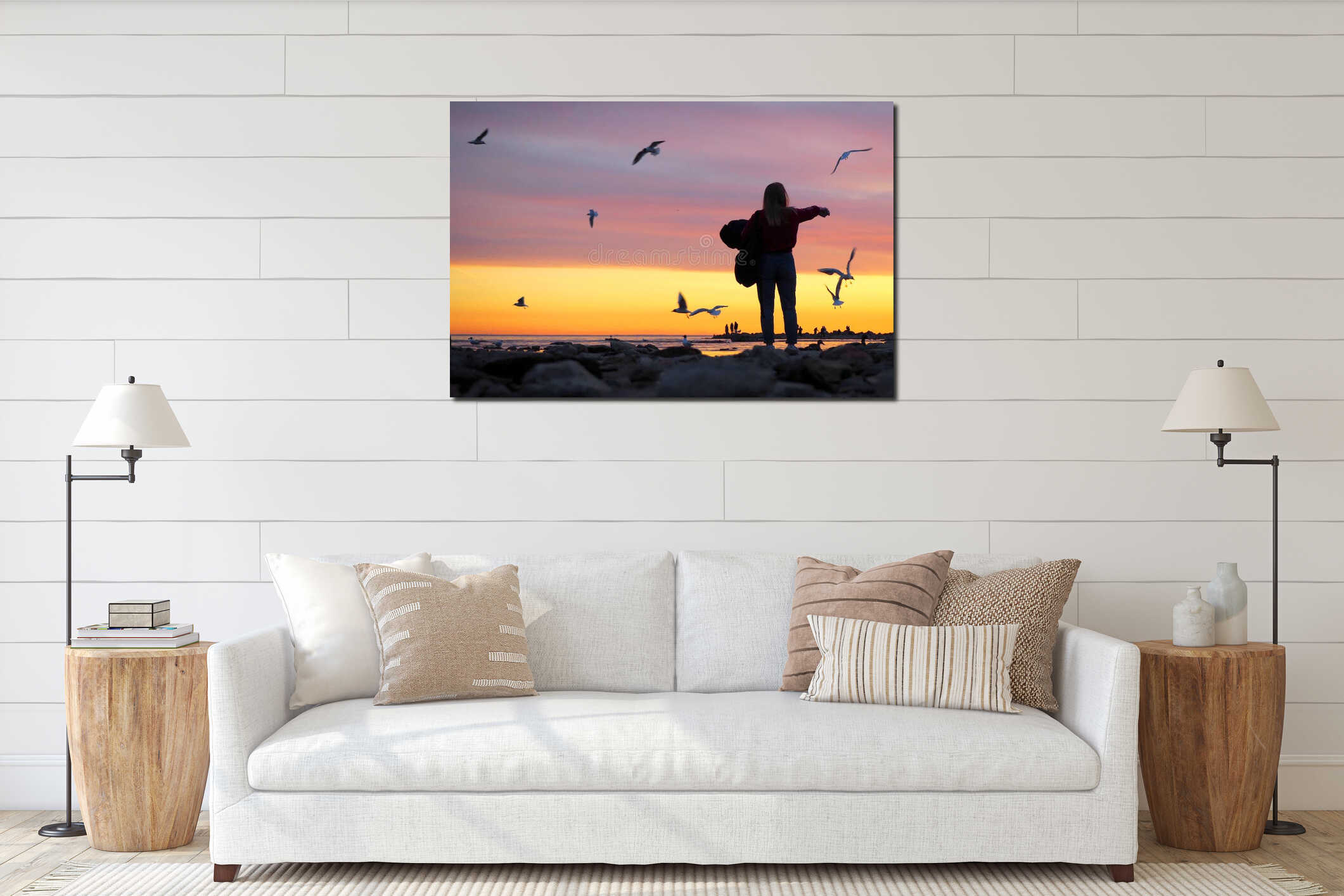 Sunset on the sea coast. Silhouettes of people. The girl feeds the seagulls with her hands interior mockup