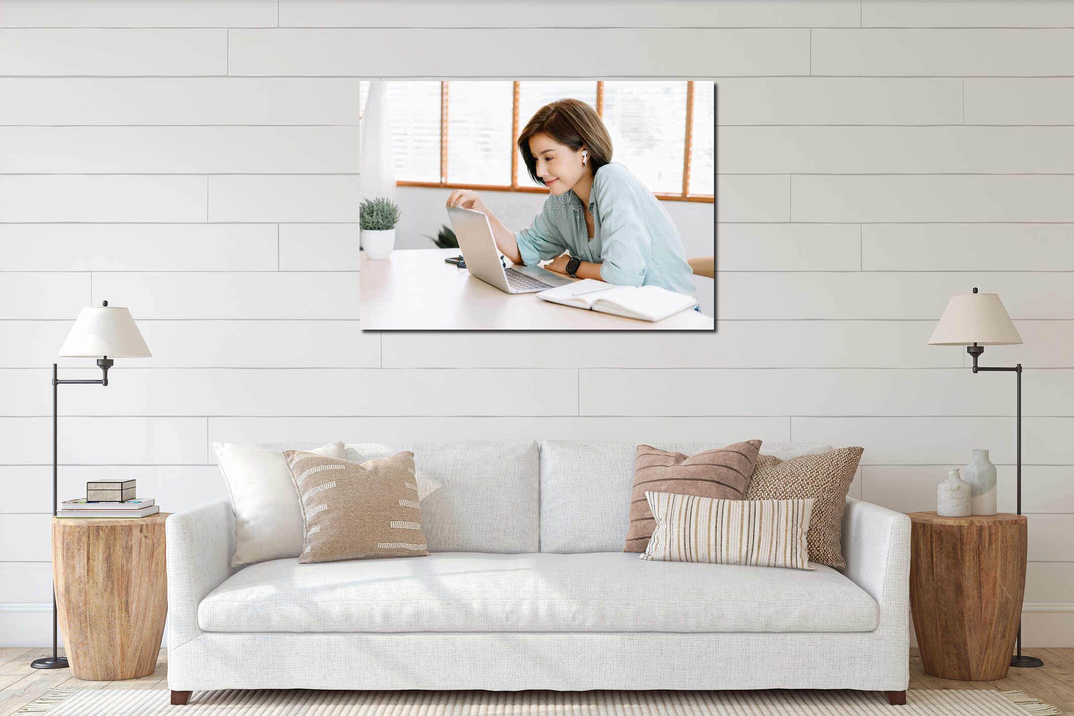 Happy young beautiful Asian woman using laptop working remote and wireless earphones sitting at table in home office.Remote work,E interior mockup