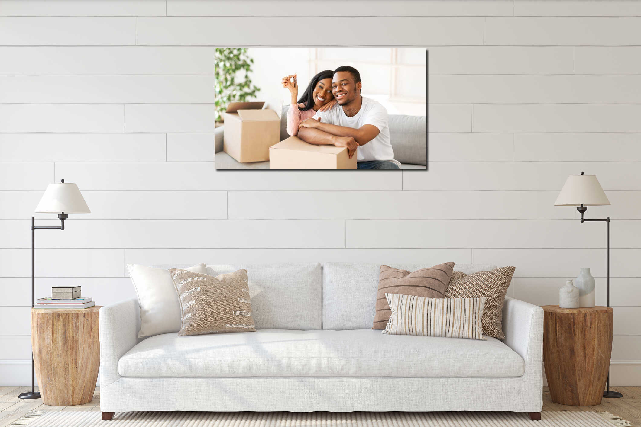 Happy black couple with house key and carton boxes looking at camera and smiling in their property, panorama interior mockup