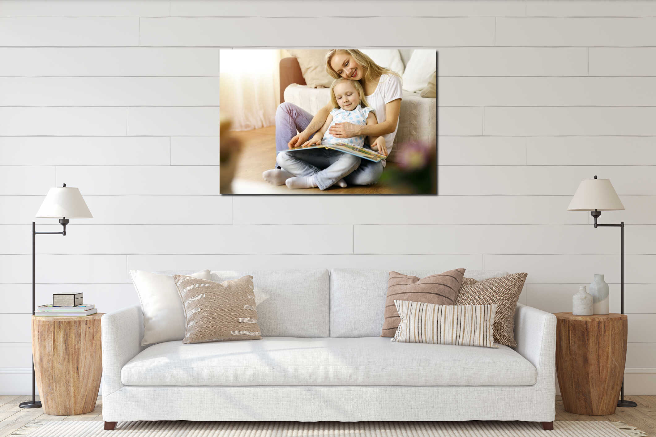 Happy family. Blonde young mother reading a book to her cute daughter while sitting at wooden floor in sunny room interior mockup