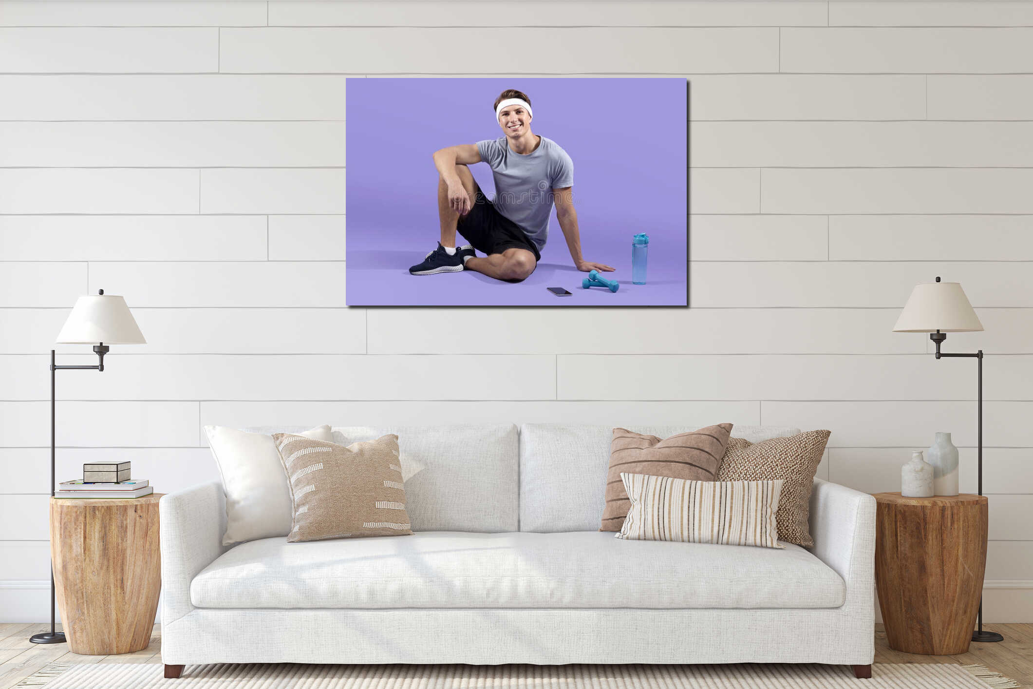 Full length portrait of young athletic man with dumbbells and bottle of water sitting on lilac studio background interior mockup