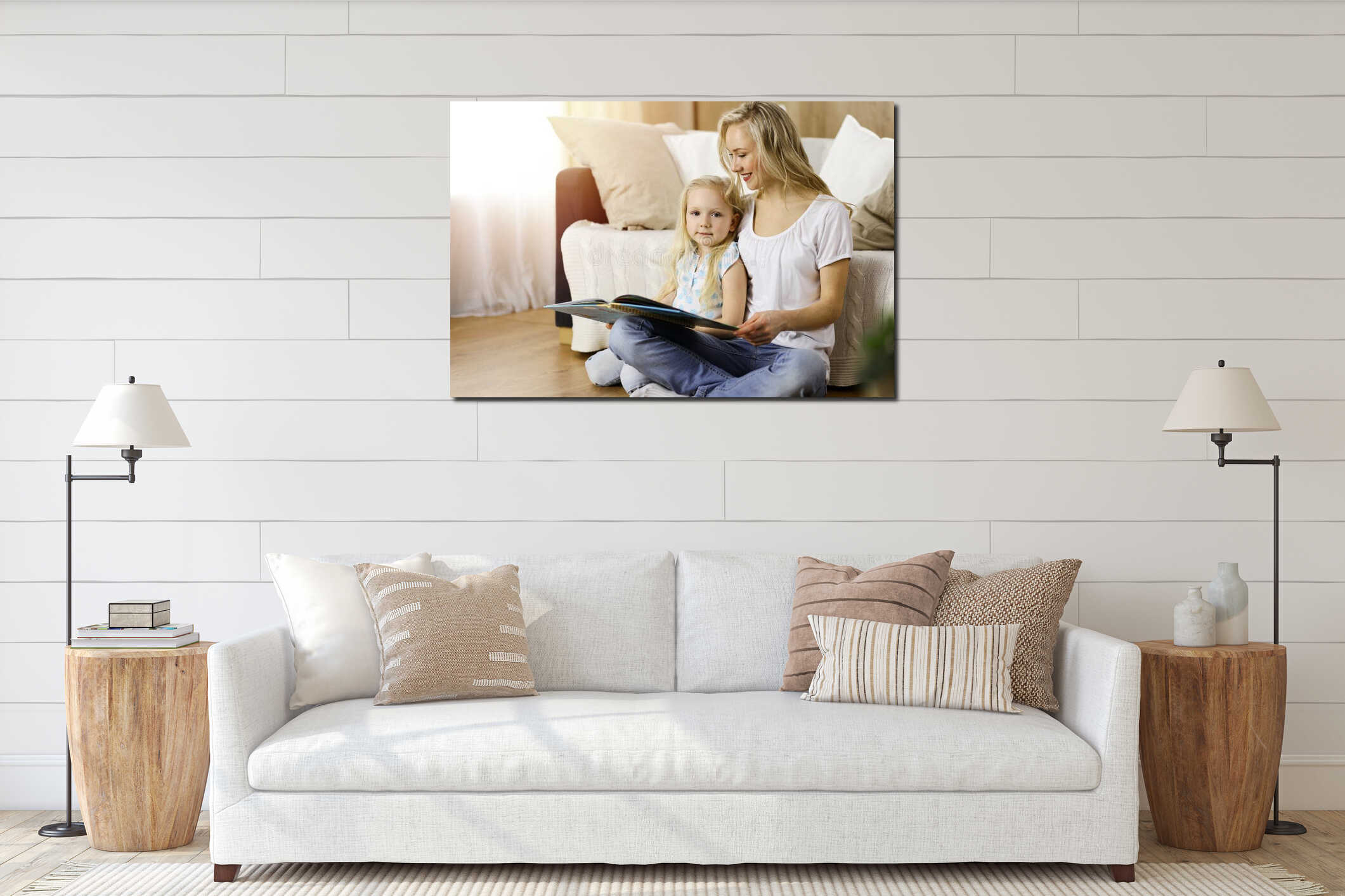 Happy family. Blonde young mother reading a book to her cute daughter while sitting at wooden floor in sunny room interior mockup
