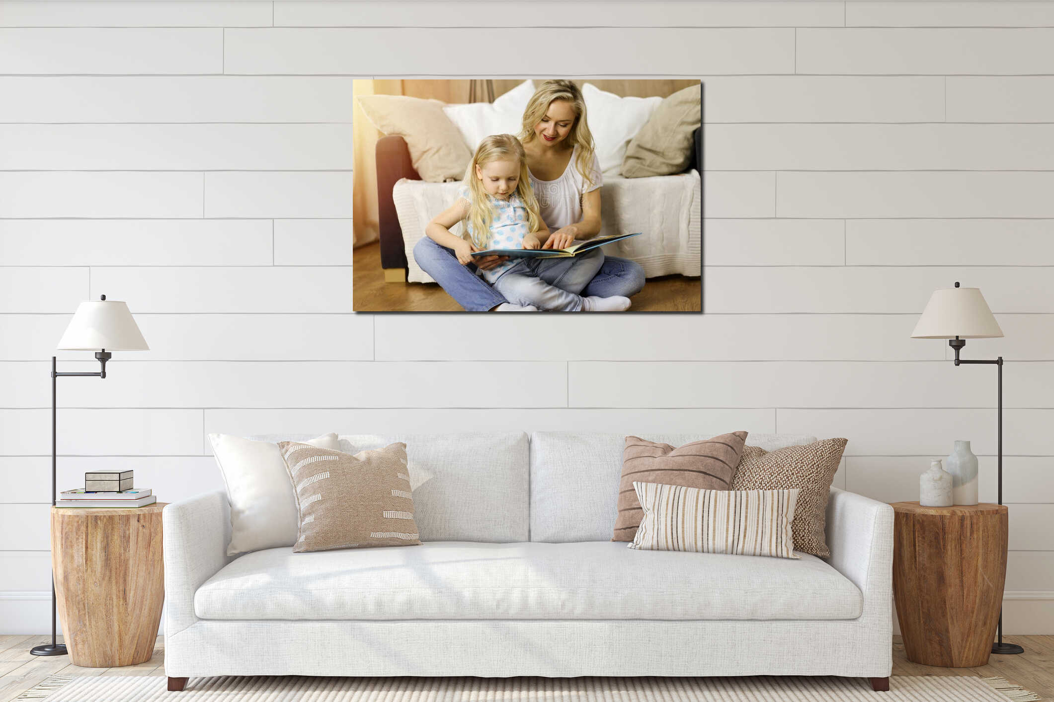 Happy family. Blonde young mother reading a book to her cute daughter while sitting at wooden floor in sunny room interior mockup