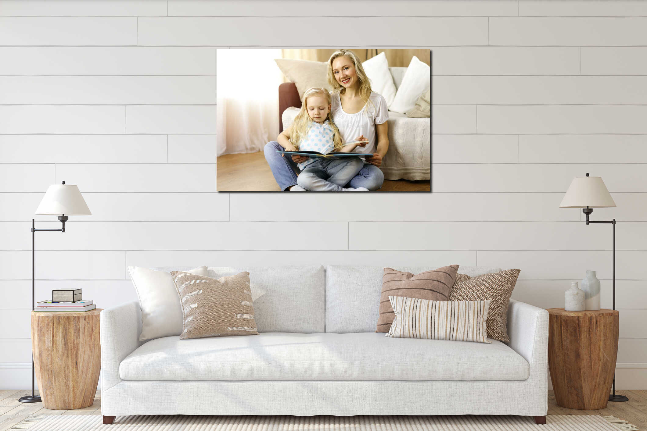 Happy family. Blonde young mother reading a book to her cute daughter while sitting at wooden floor in sunny room interior mockup