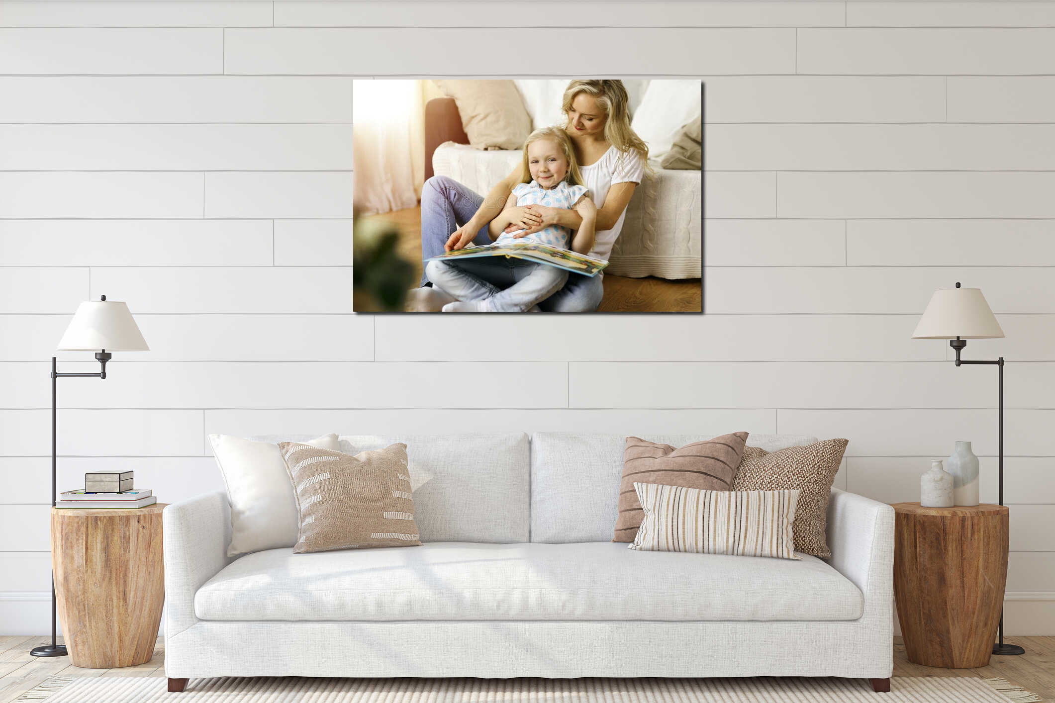 Happy family. Blonde young mother reading a book to her cute daughter while sitting at wooden floor in sunny room interior mockup