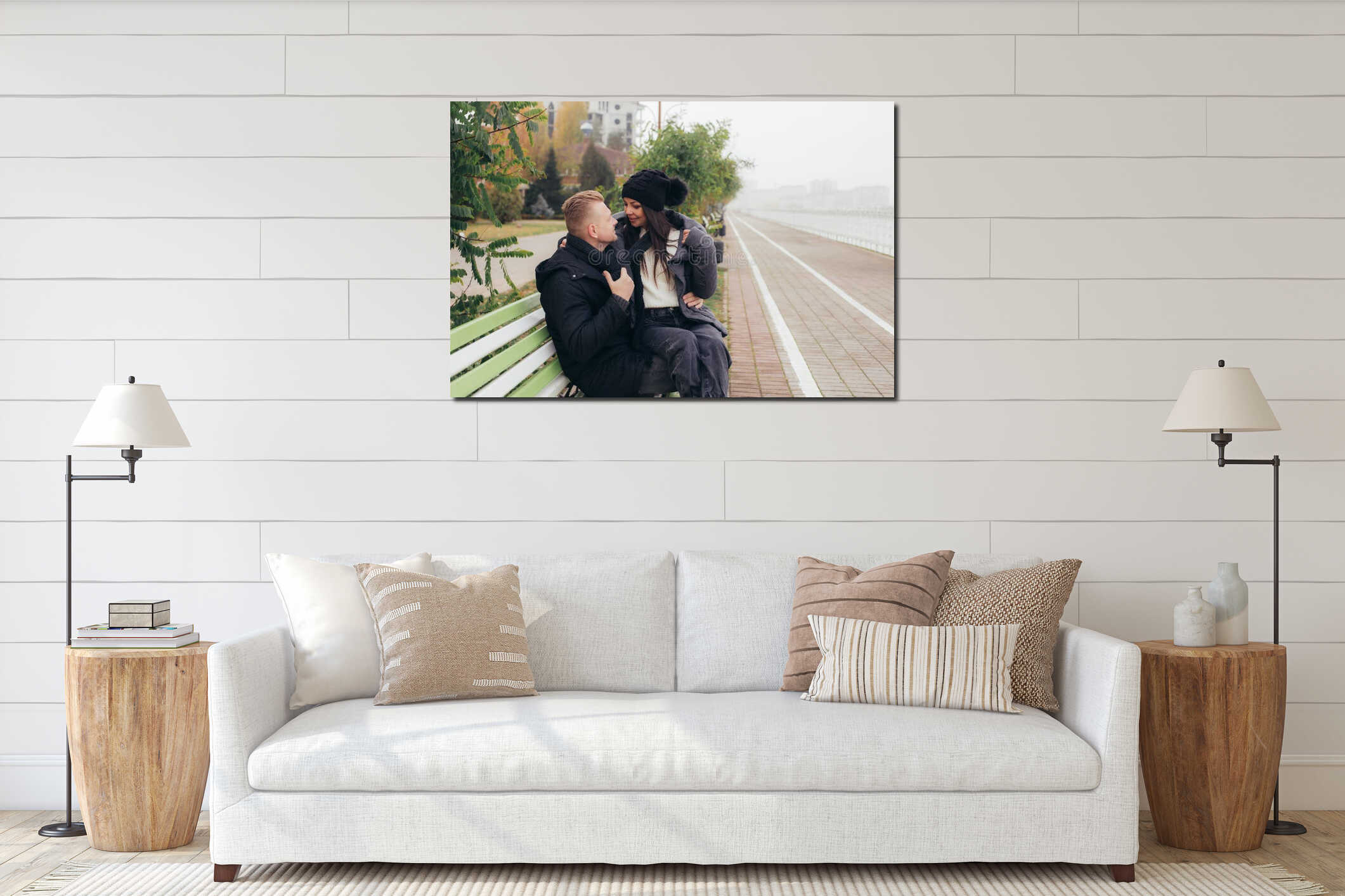 A young couple in love sits on a bench on the embankment, smiling and looking into each other's eyes interior mockup