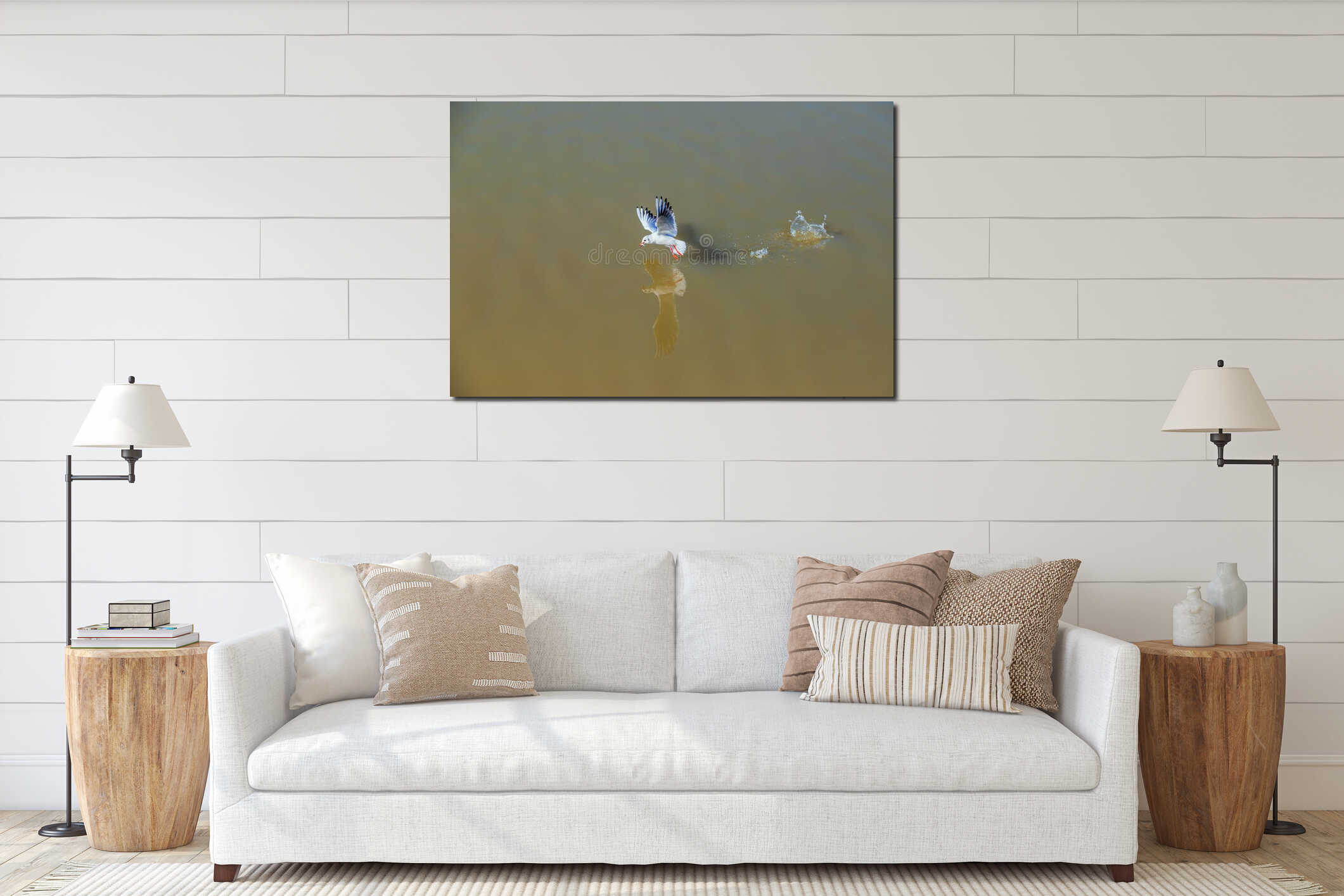A seagull flies just above the surface of the pond and catches fish. His image is reflected in the water. The seagull has a fish interior mockup