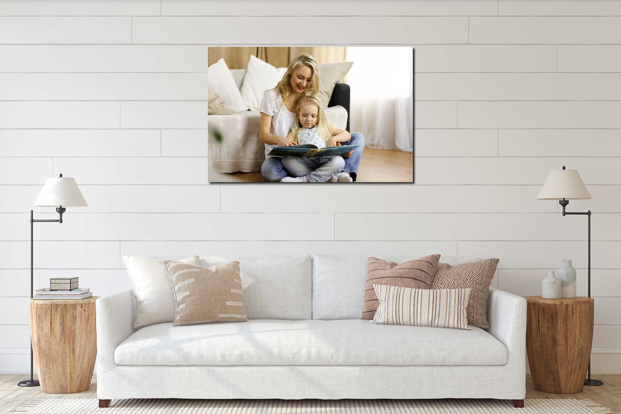 Happy family. Blonde young mother reading a book to her cute daughter while sitting at wooden floor. Motherhood concept interior mockup