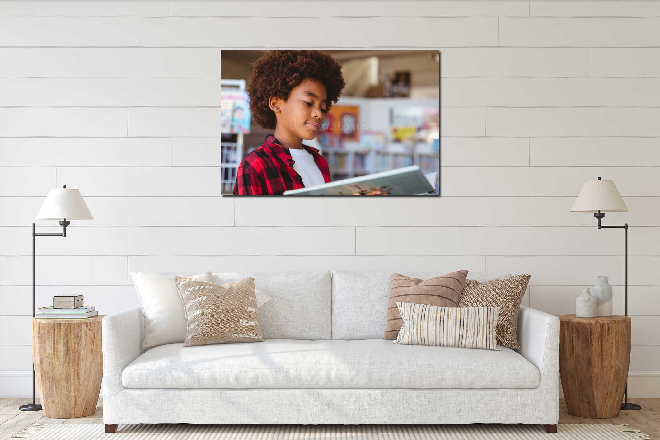 Smiling african american schoolboy reading book standing in school library interior mockup