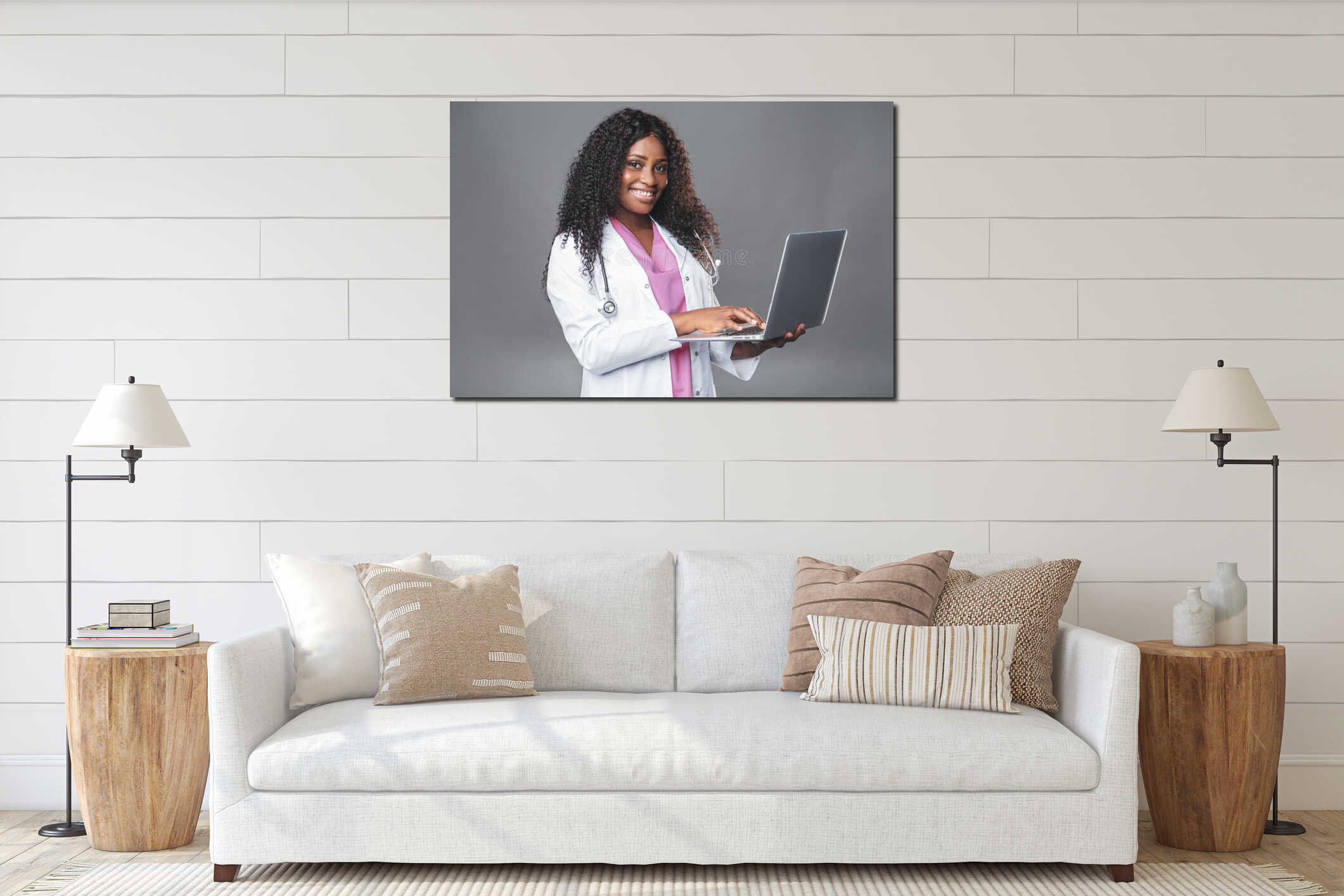 Happy professional doctor dark-skinned woman in a white laboratory coat with a stethoscope and a laptop stands in a medical office interior mockup