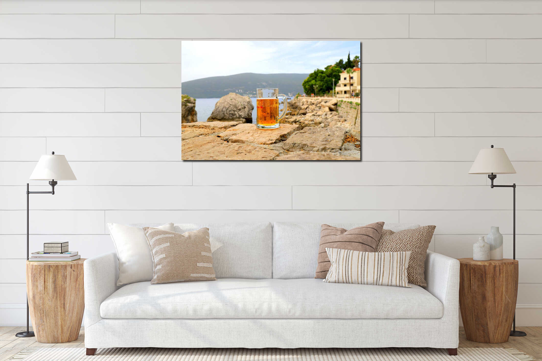 Glass of beer on background of sea, close-up. A fogged mug, a glass of cold beer stands against of sea and mountain landscape in interior mockup