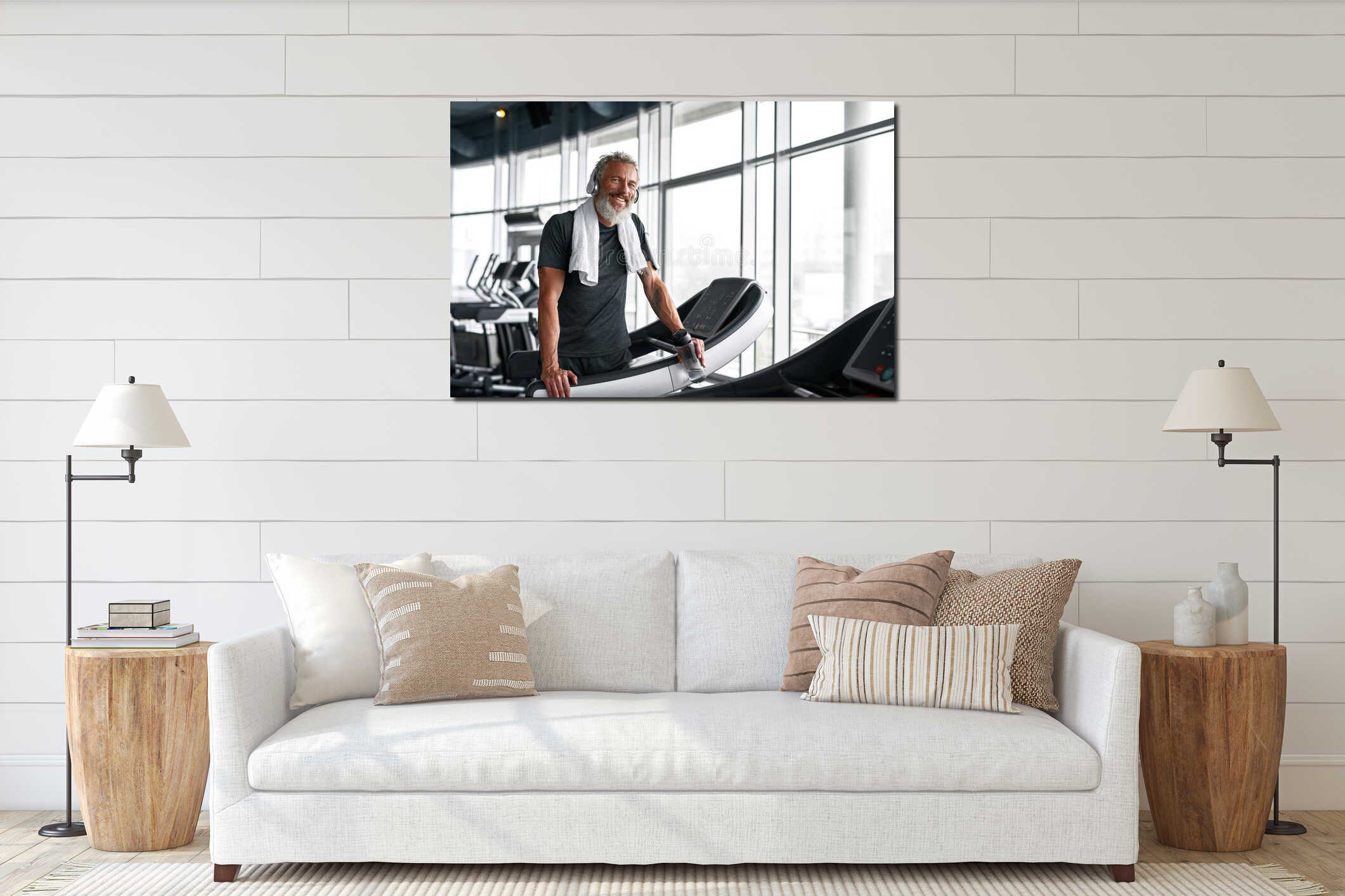 Cheerful grey-haired man with towel around neck, posing in gym interior mockup