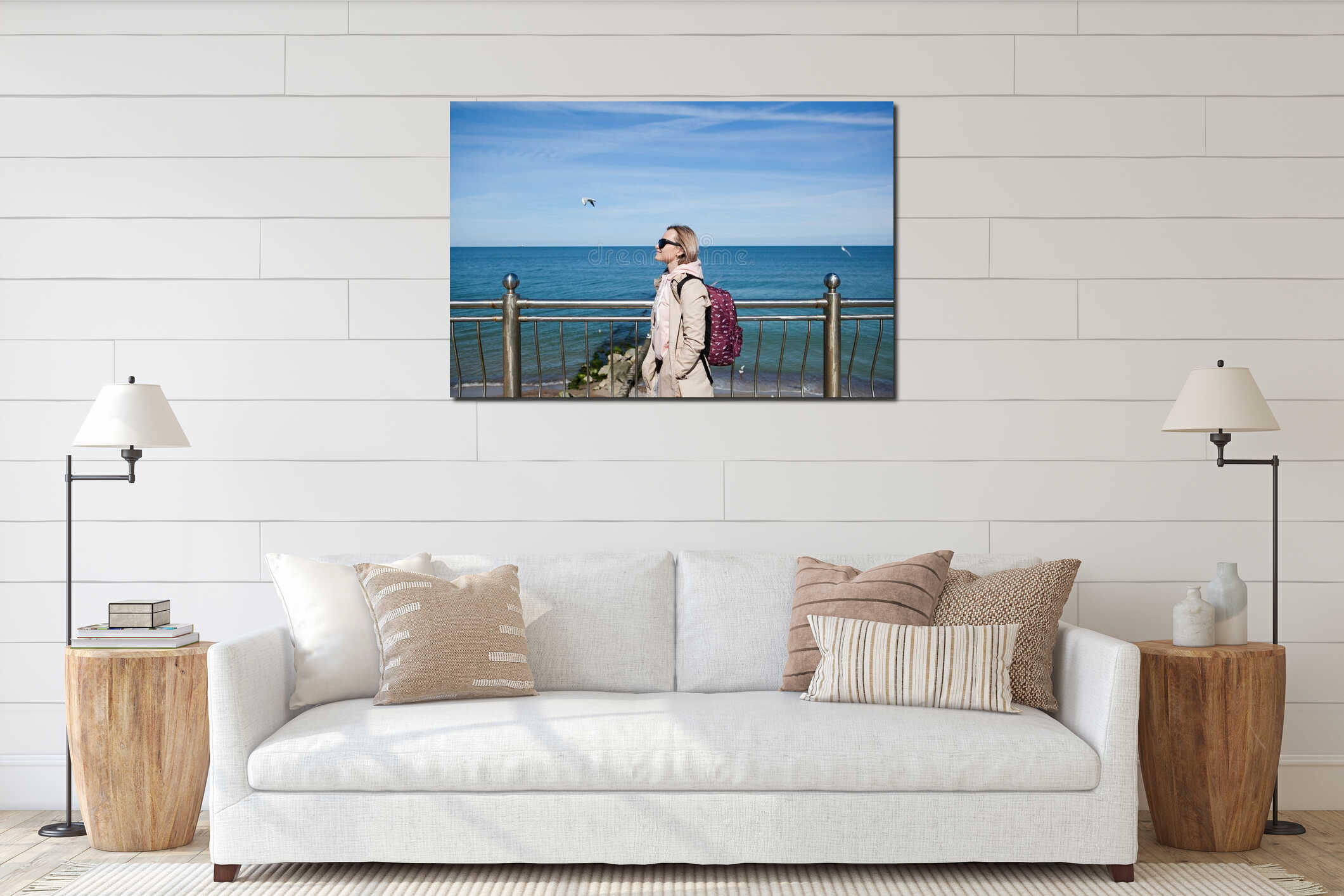 A blonde girl with a backpack on the background of a cold sea, seagulls in the sky. the concept of travel and trips interior mockup