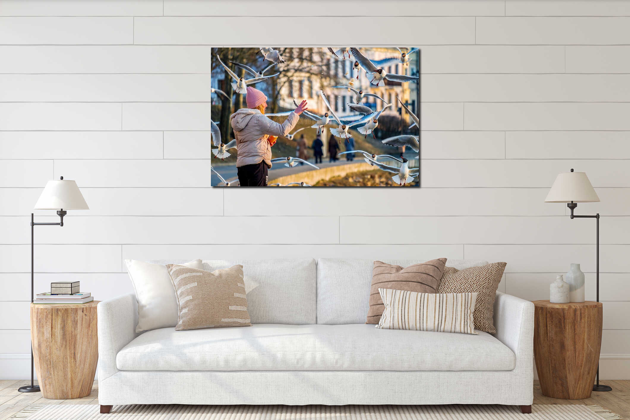 Girl feeds seagulls on the embankment of the Svisloch river in the spring evening interior mockup