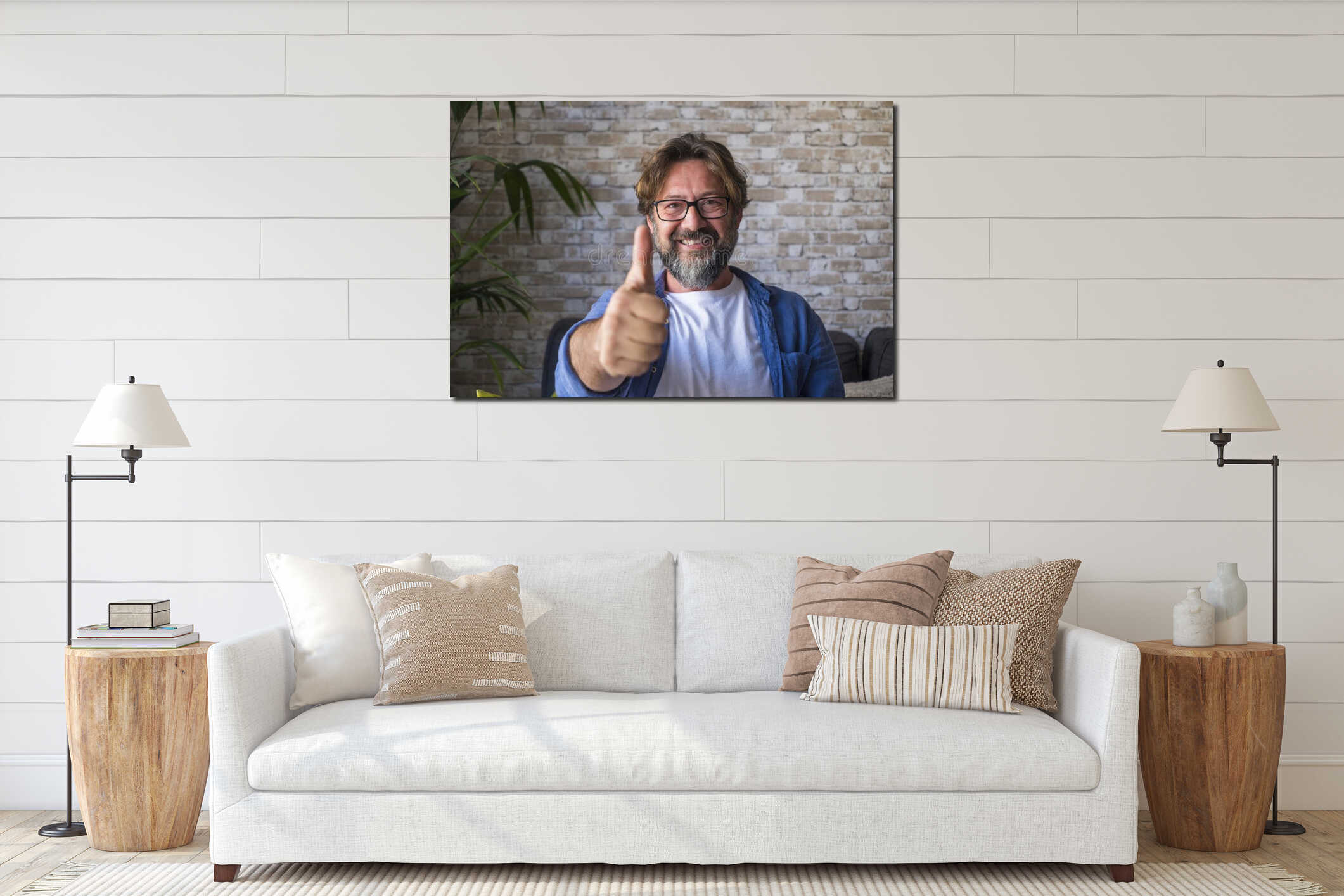 Portrait of cheerful mature man in eyeglasses giving approval or appreciations sign by gesturing thumbs up in front of brick wall interior mockup