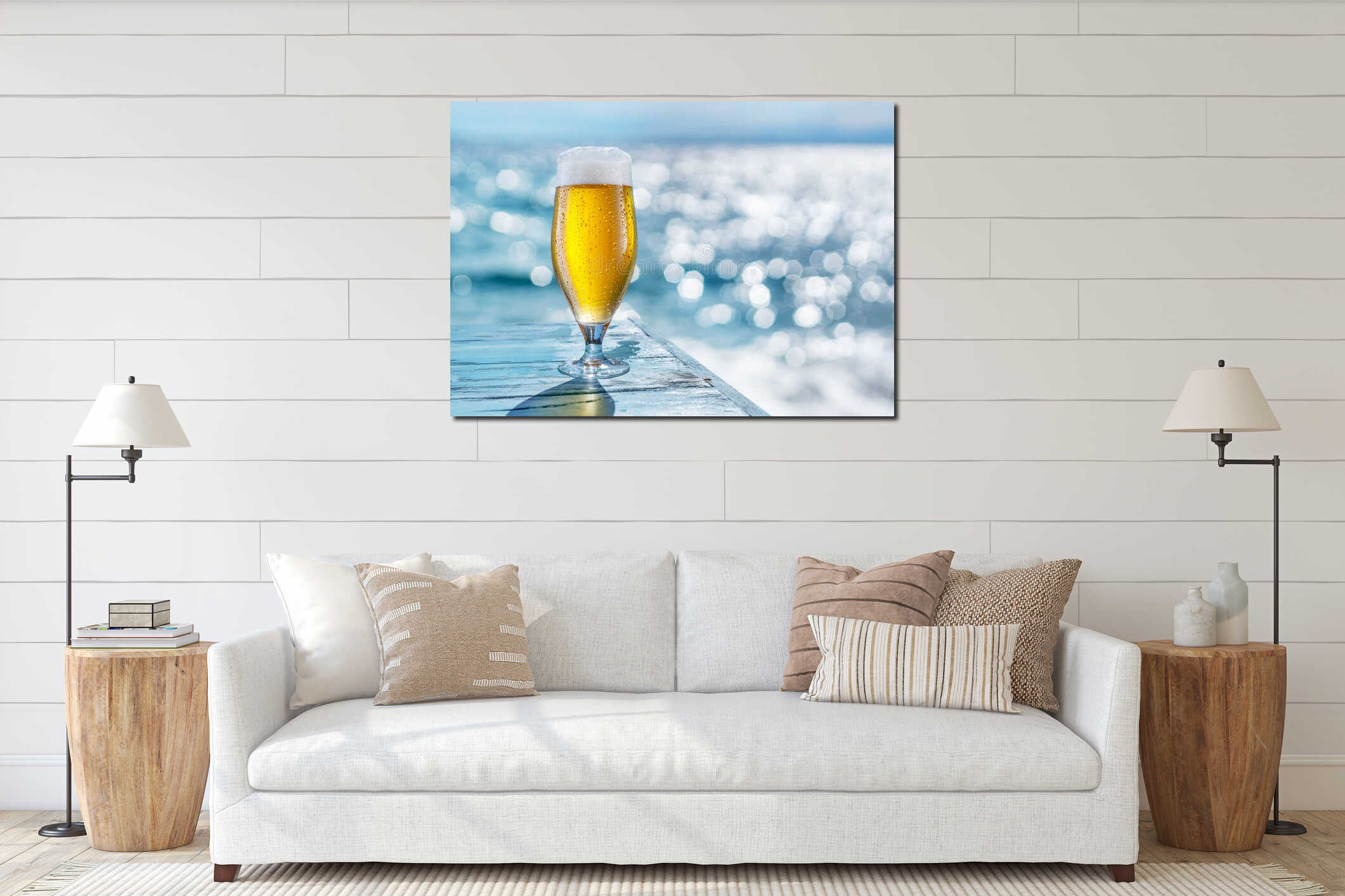 Cooled glass of beer with condensation drops on the blue wooden table. Blurred sea is at the background interior mockup