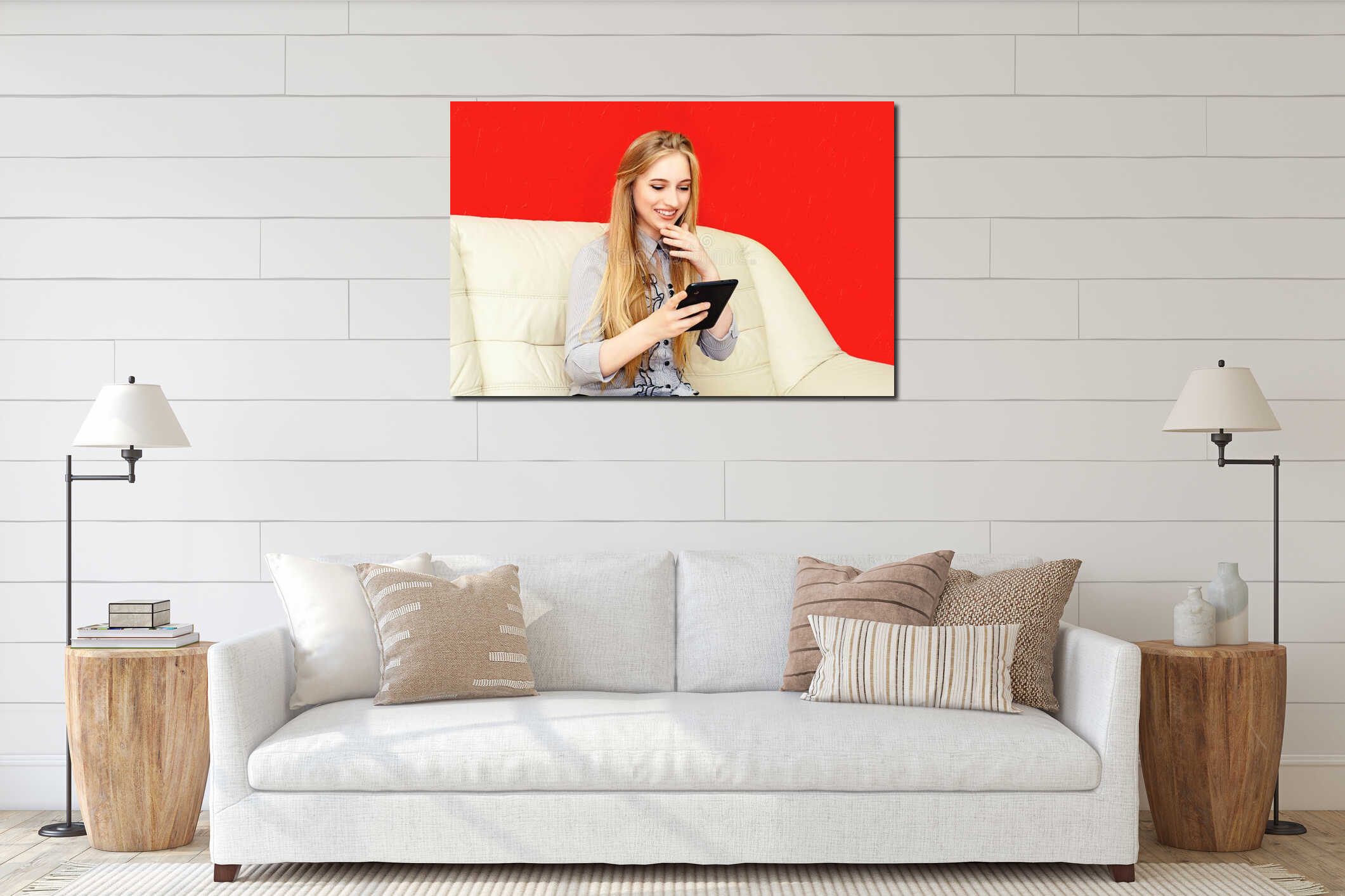 Beautiful blonde businesswoman with smartphone in office sitting on white leather sofa on red wall background interior mockup