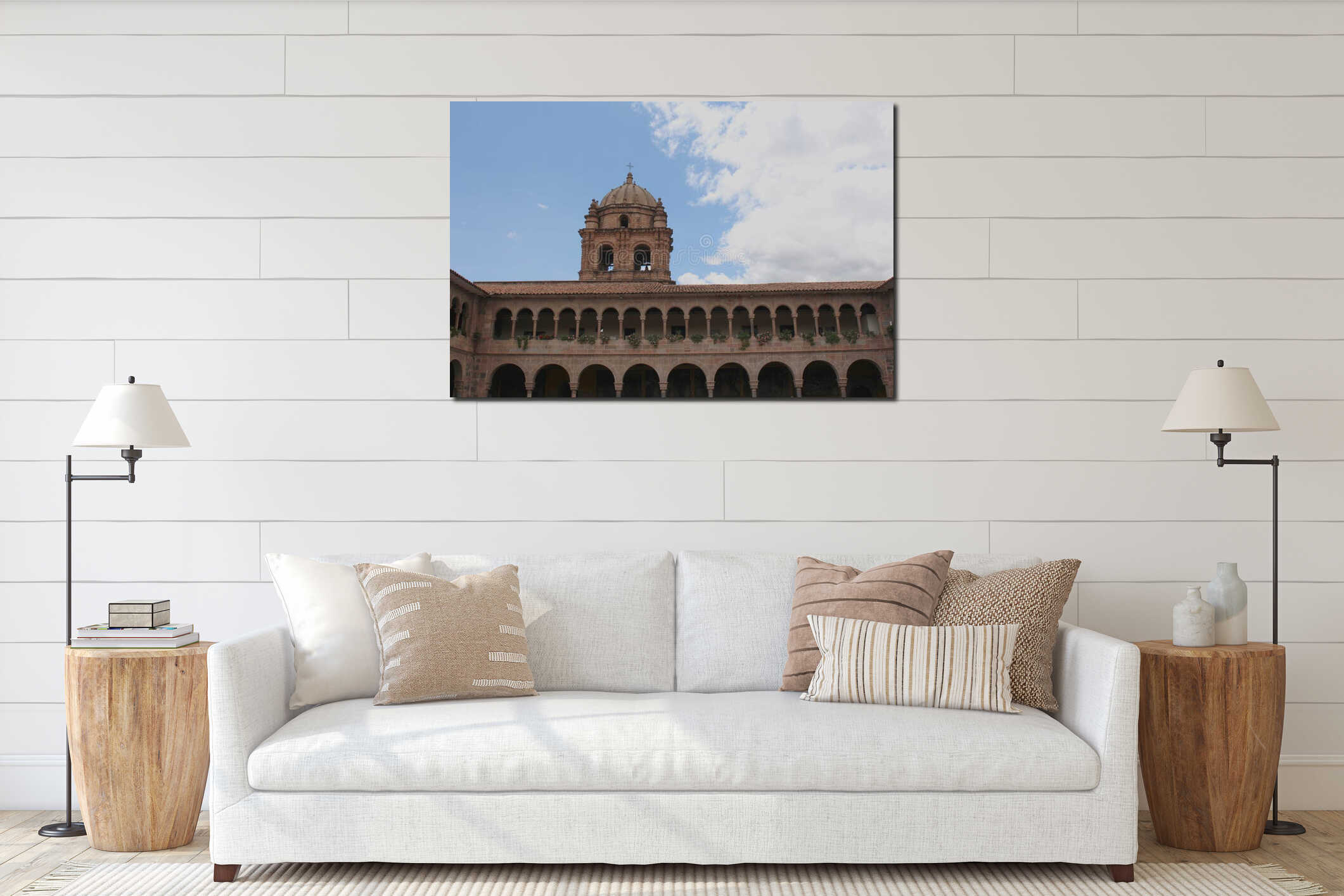 A bell tower atop a two-story stone wall lined with columns and arches and filled with flowers at the Belmond Monasterio Hotel interior mockup